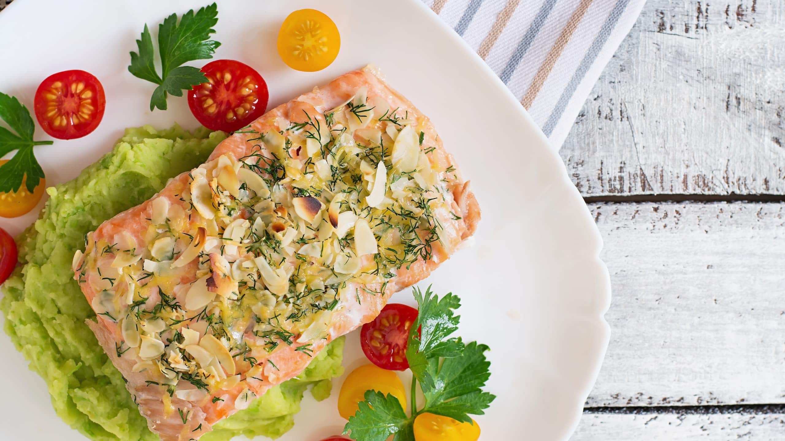 Baked stuffed salmon with crabmeat and shrimp garnished with almond crust on mashed potatoes