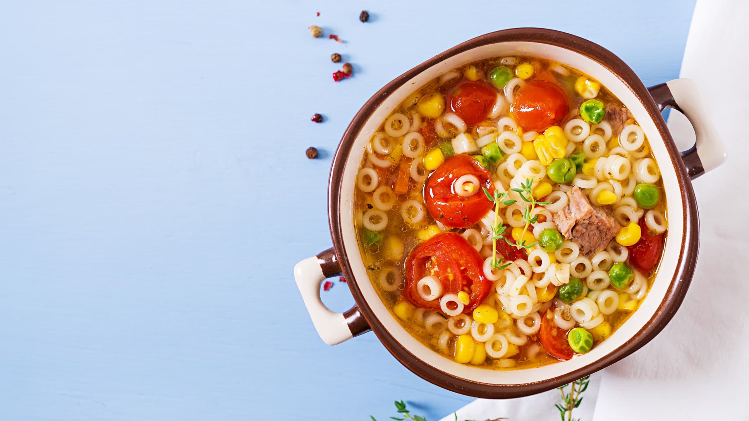 Busy day soup with small pasta rings, vegetables and pieces of meat bowl