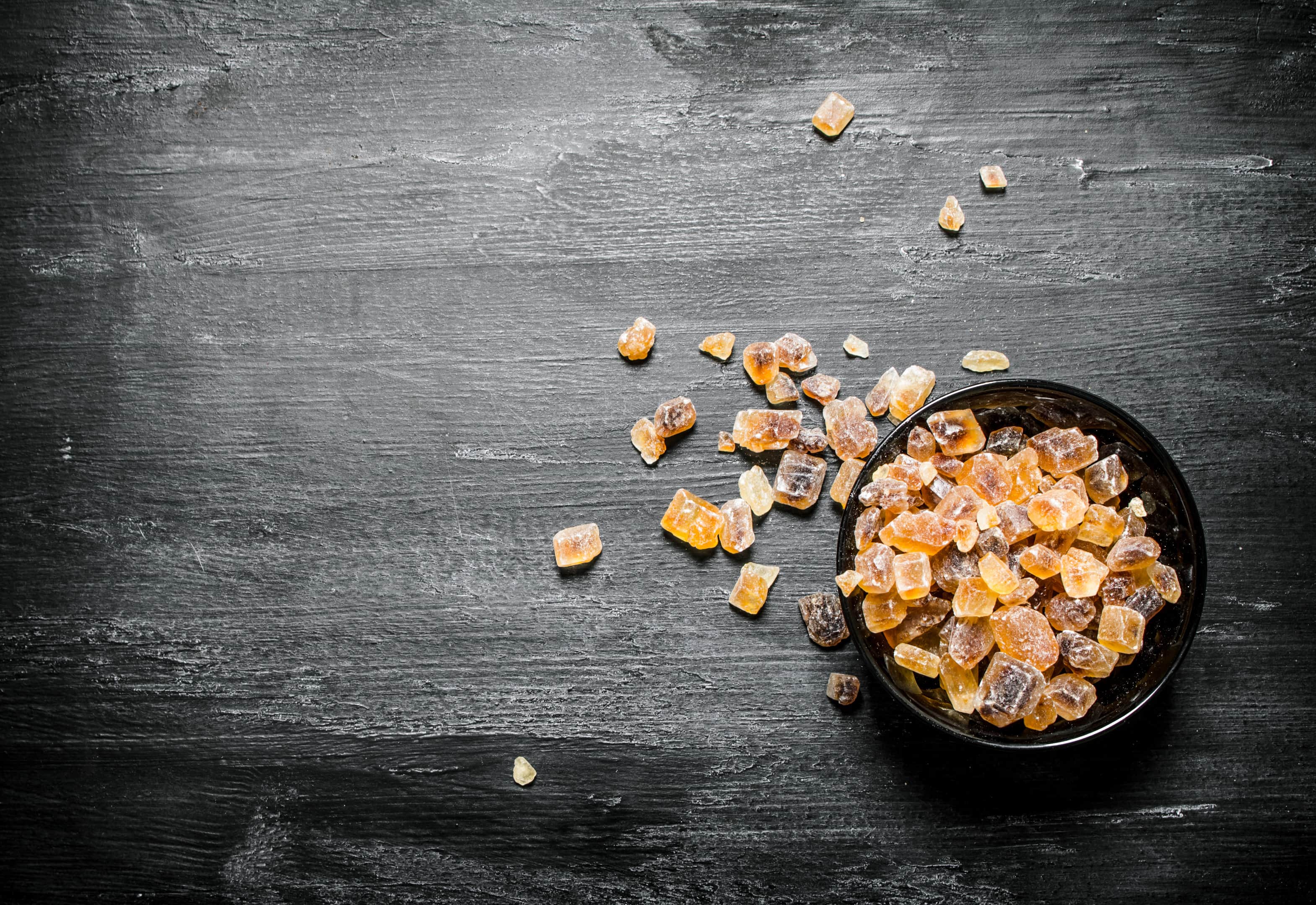 Crystal sucanat sugar on black rustic table