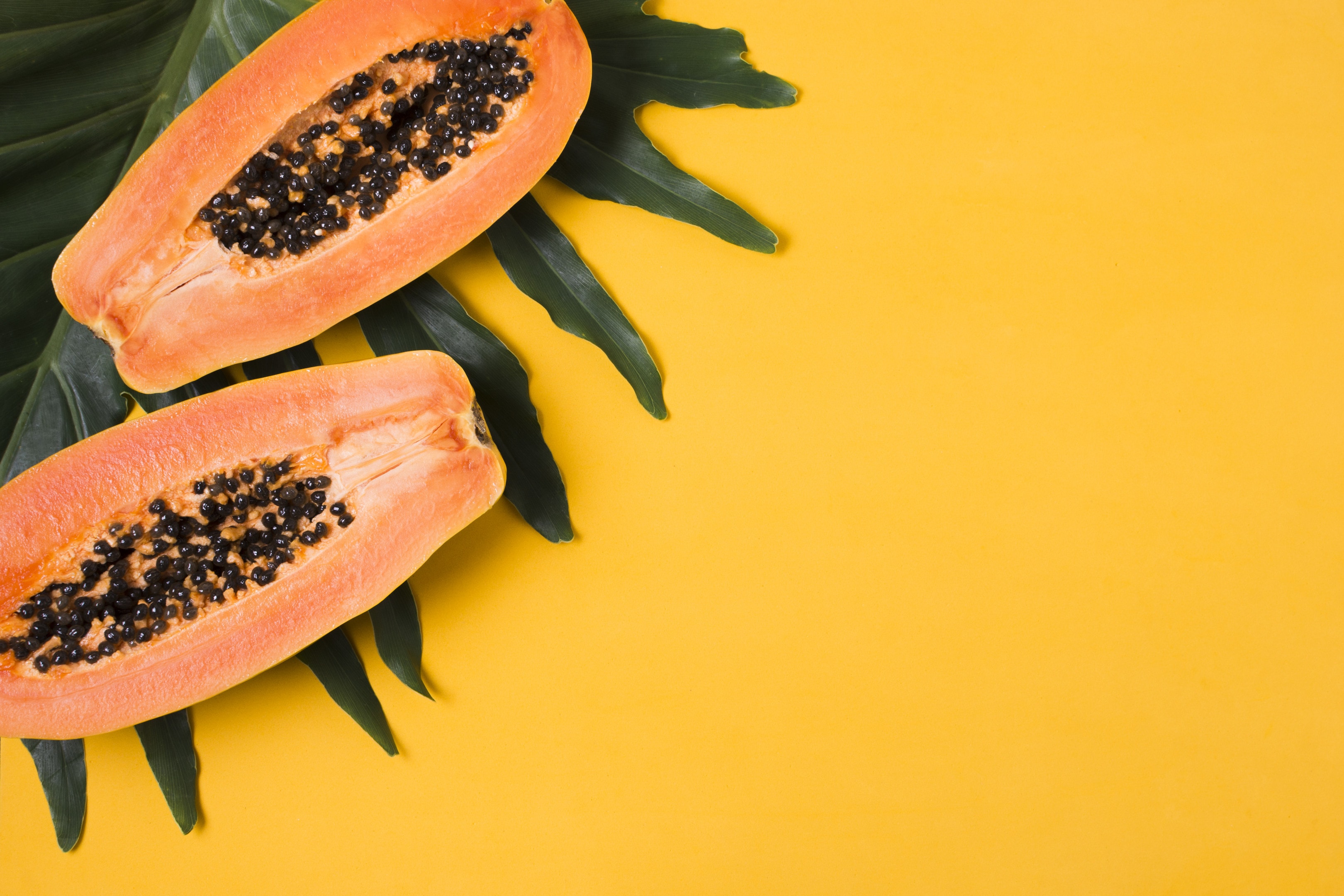 Fresh papayas on yellow background