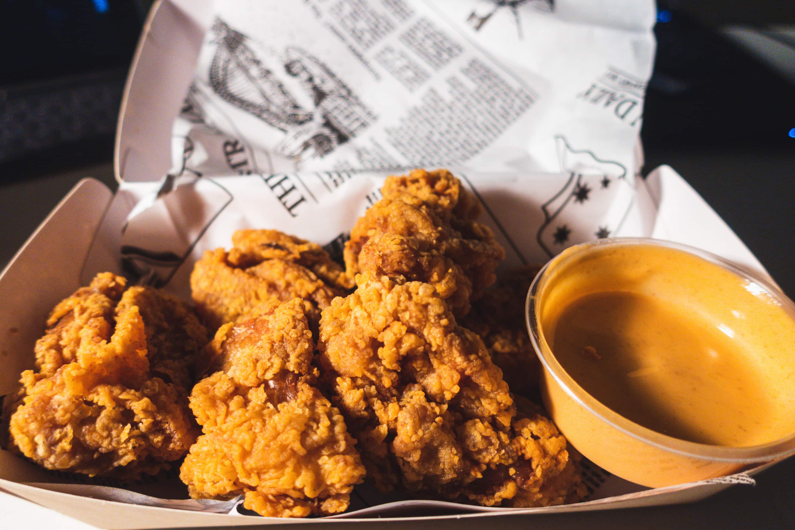 Fried chicken and hot sauce in a takeout container