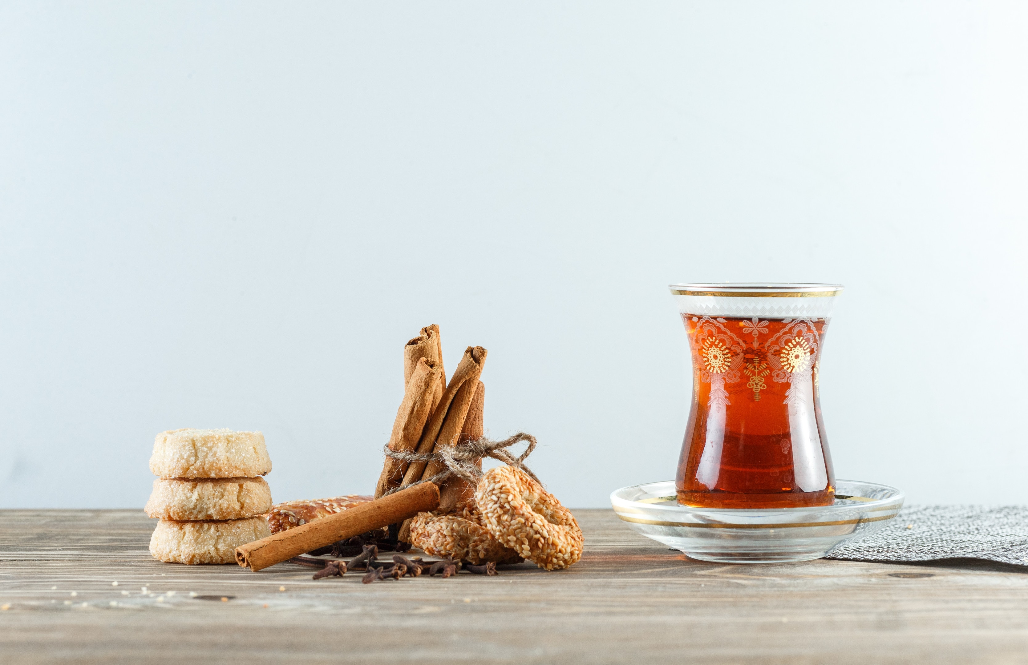 Glass of tea with cloves and biscuits