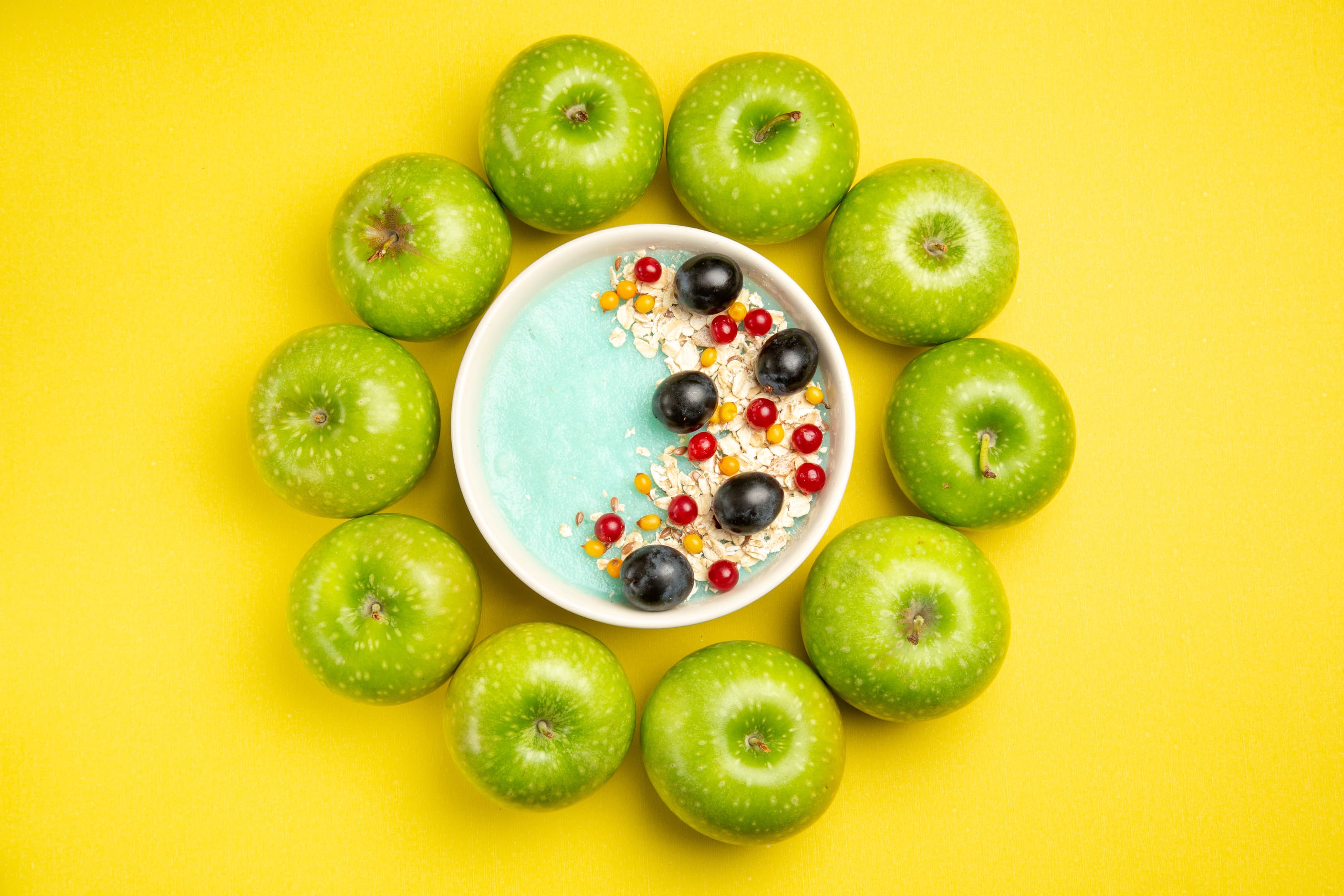 Granola & yogurt bowl with apples, red grapes and berries
