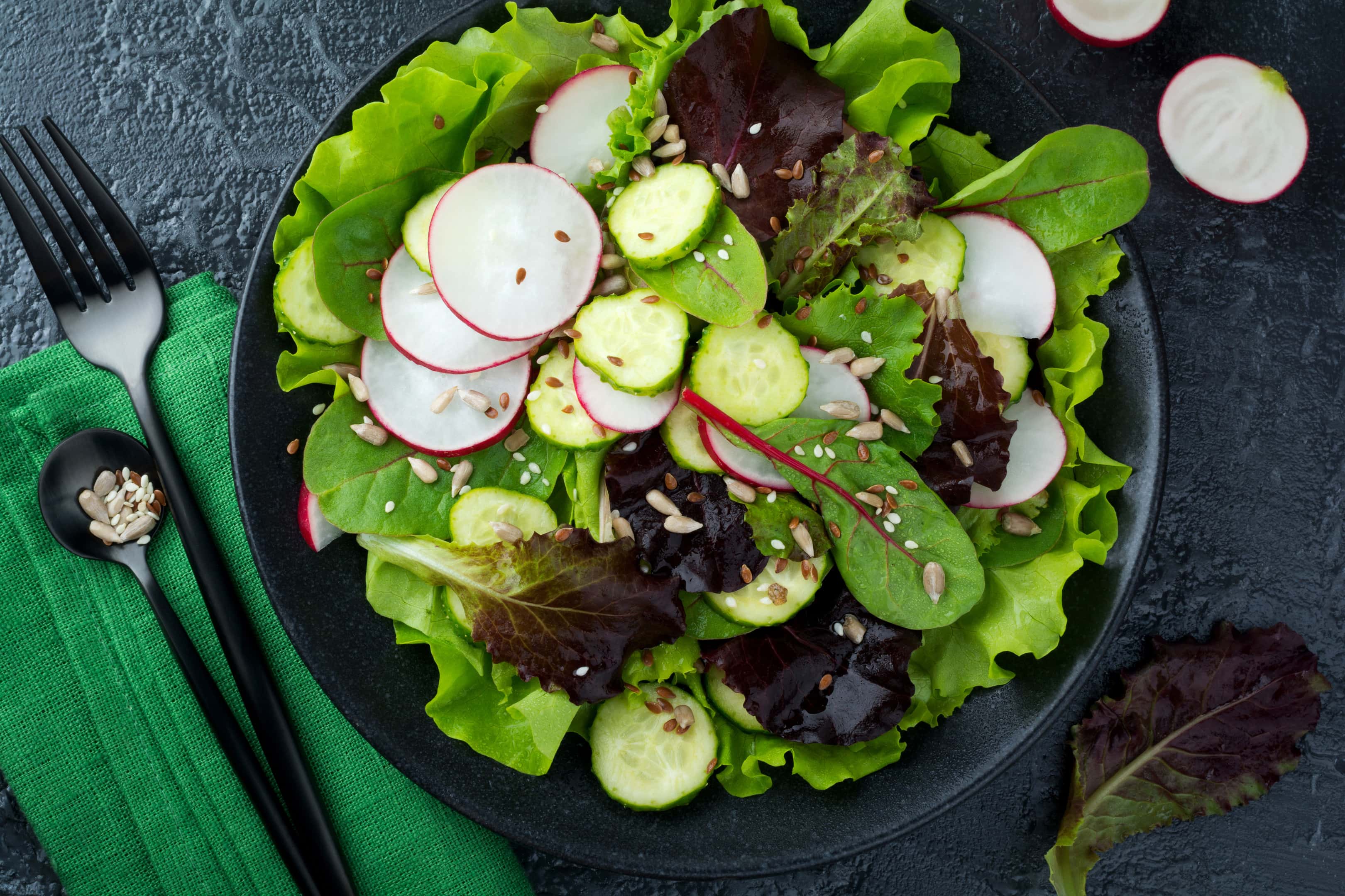 Green salad with fresh radishes, arugula, sunflower, flax seeds and sesame seeds