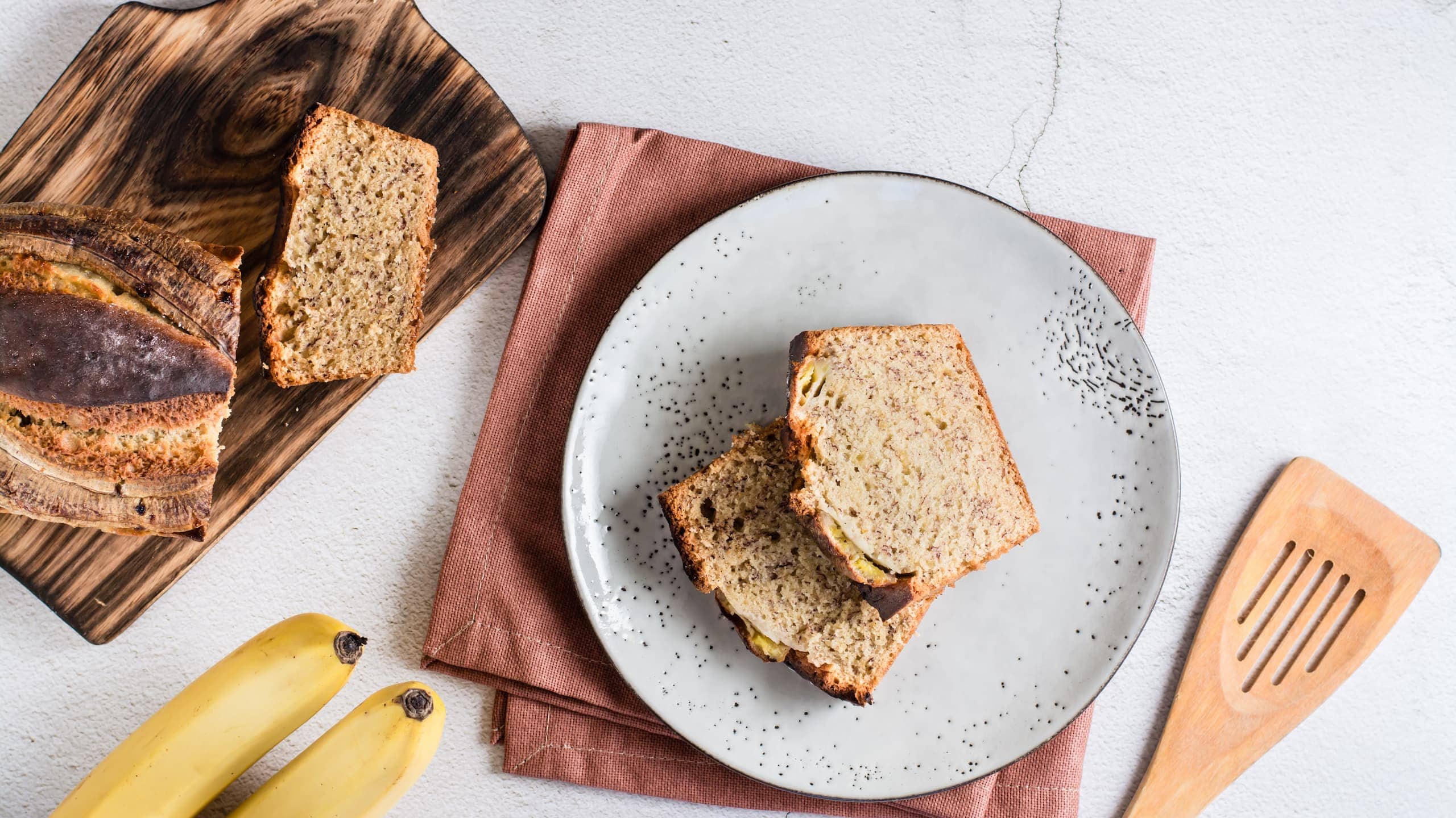 Banana bread slices with butter on a cutting board