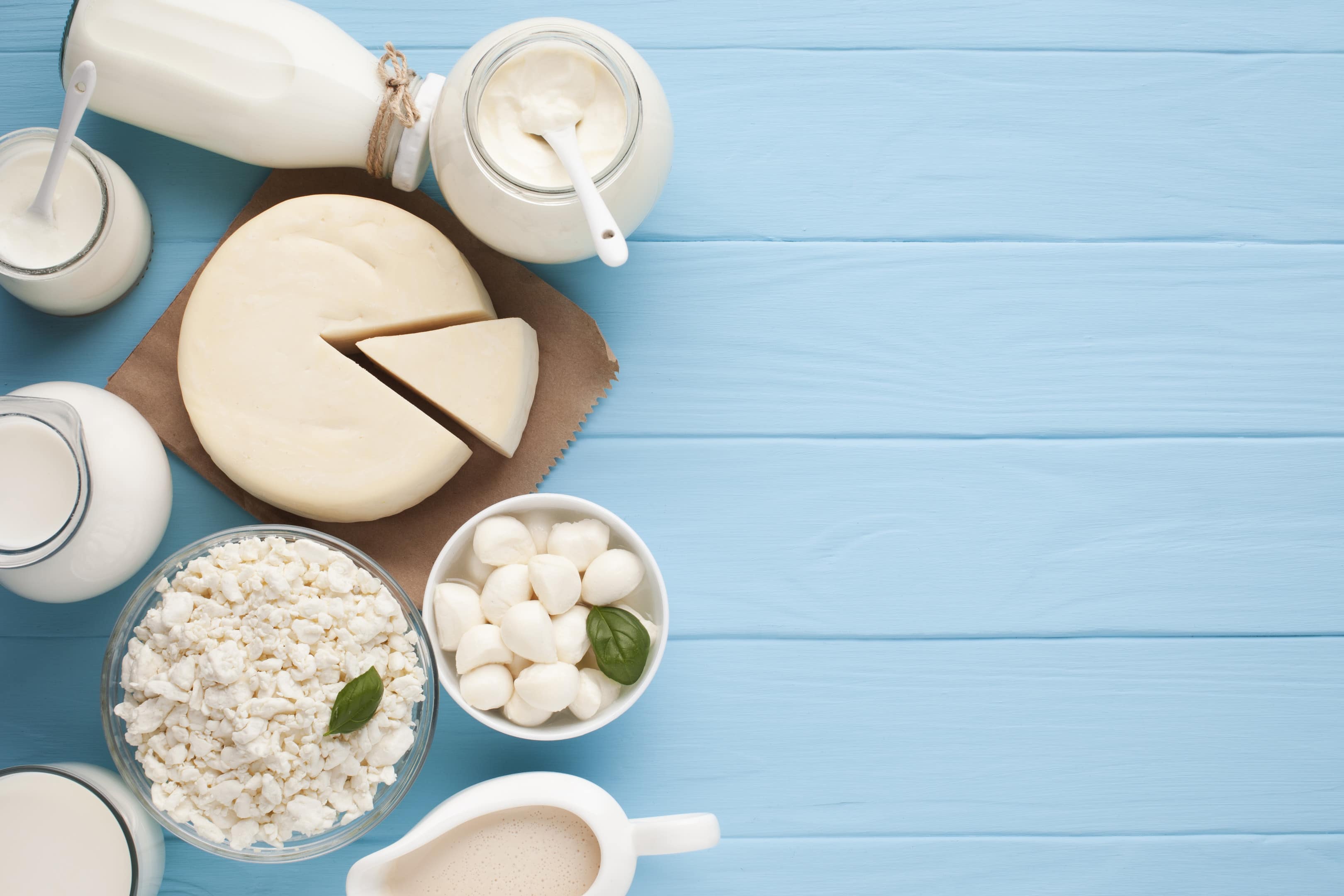 Jars of milk and dairy product on blue wooden background