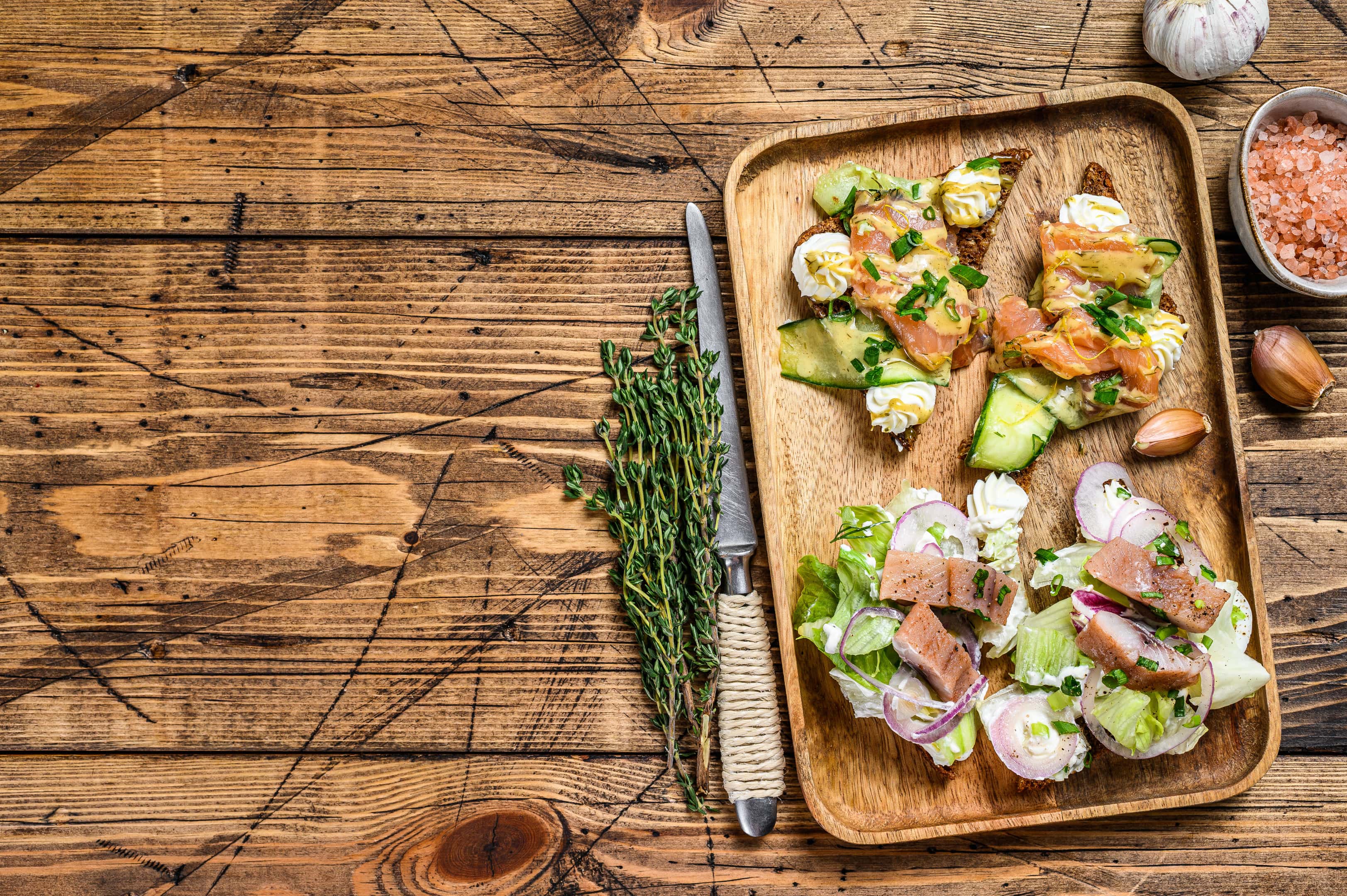 Open sandwich with salmon, herring, cream cheese and salad