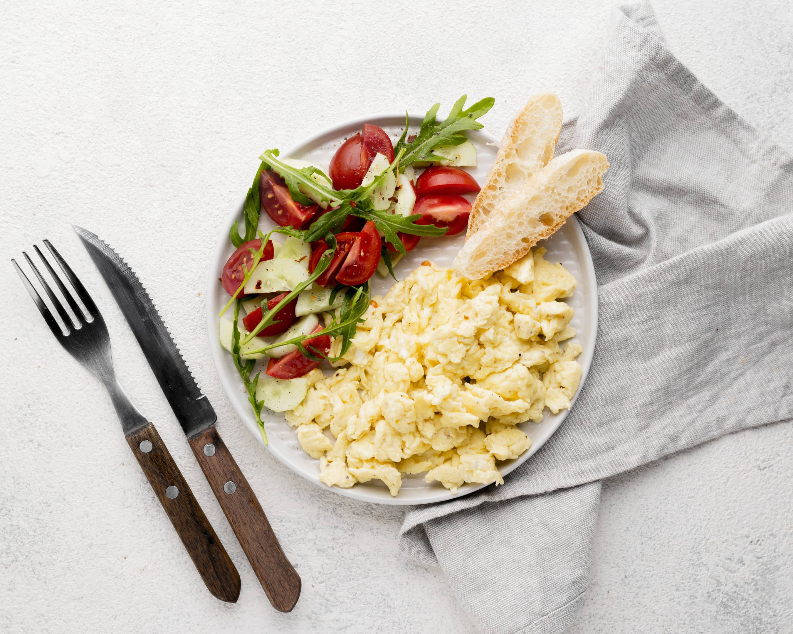 A plate of scrambled eggs and salad