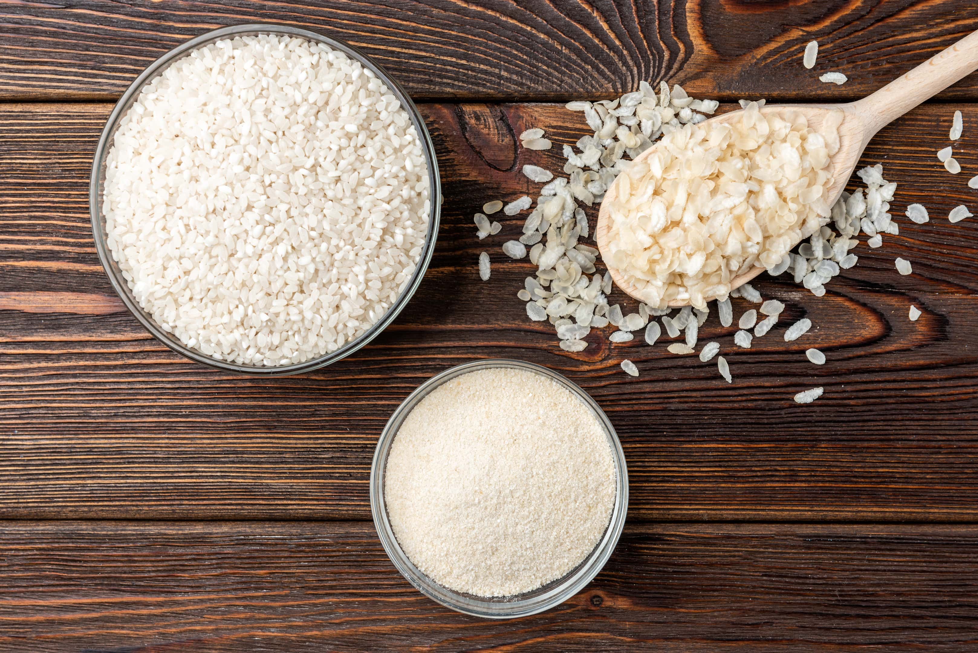 Rice flour and rice flakes on wooden table