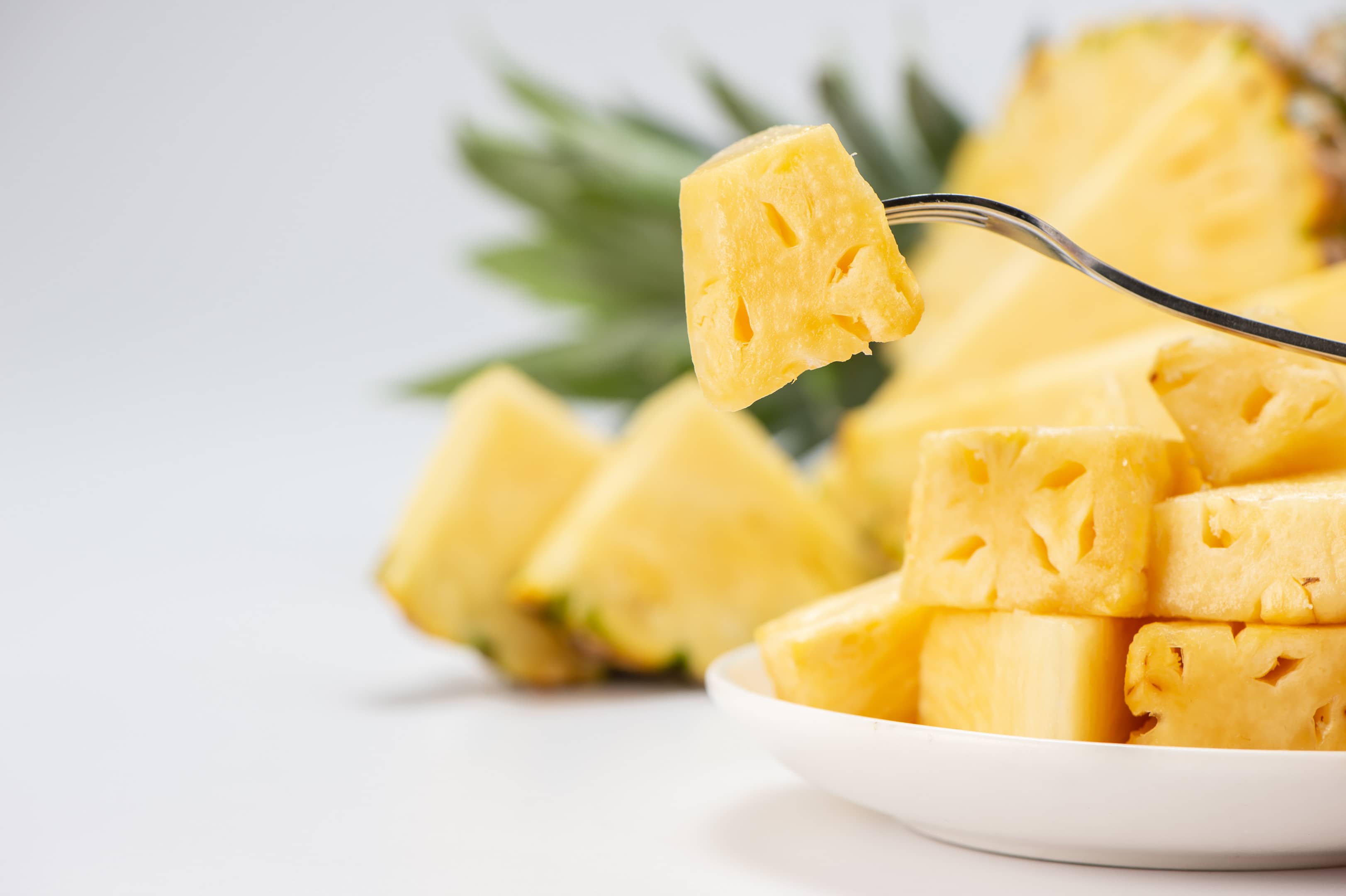 Sliced pineapple on white plate