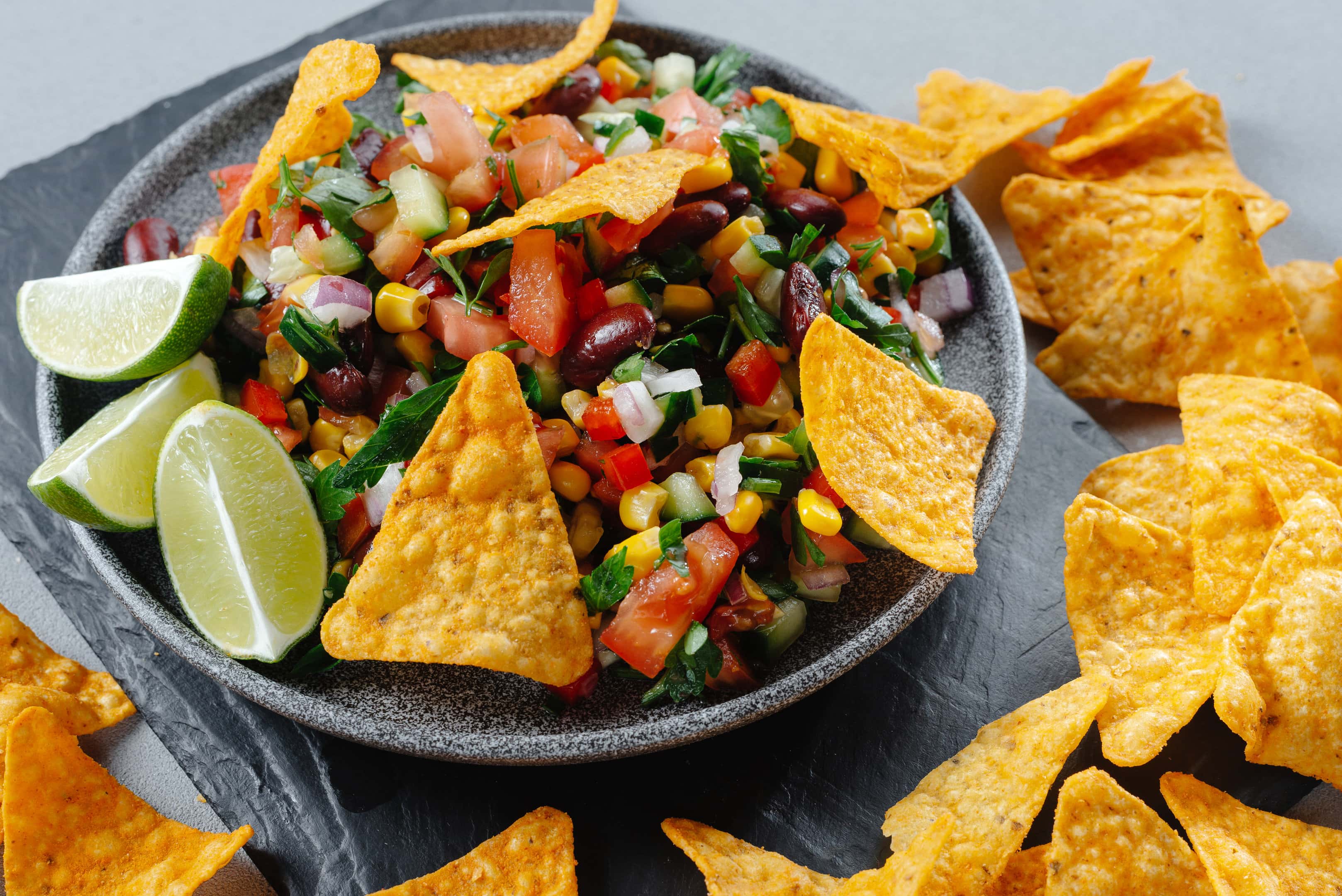 Cowboy caviar with tortilla chips and lime wedges