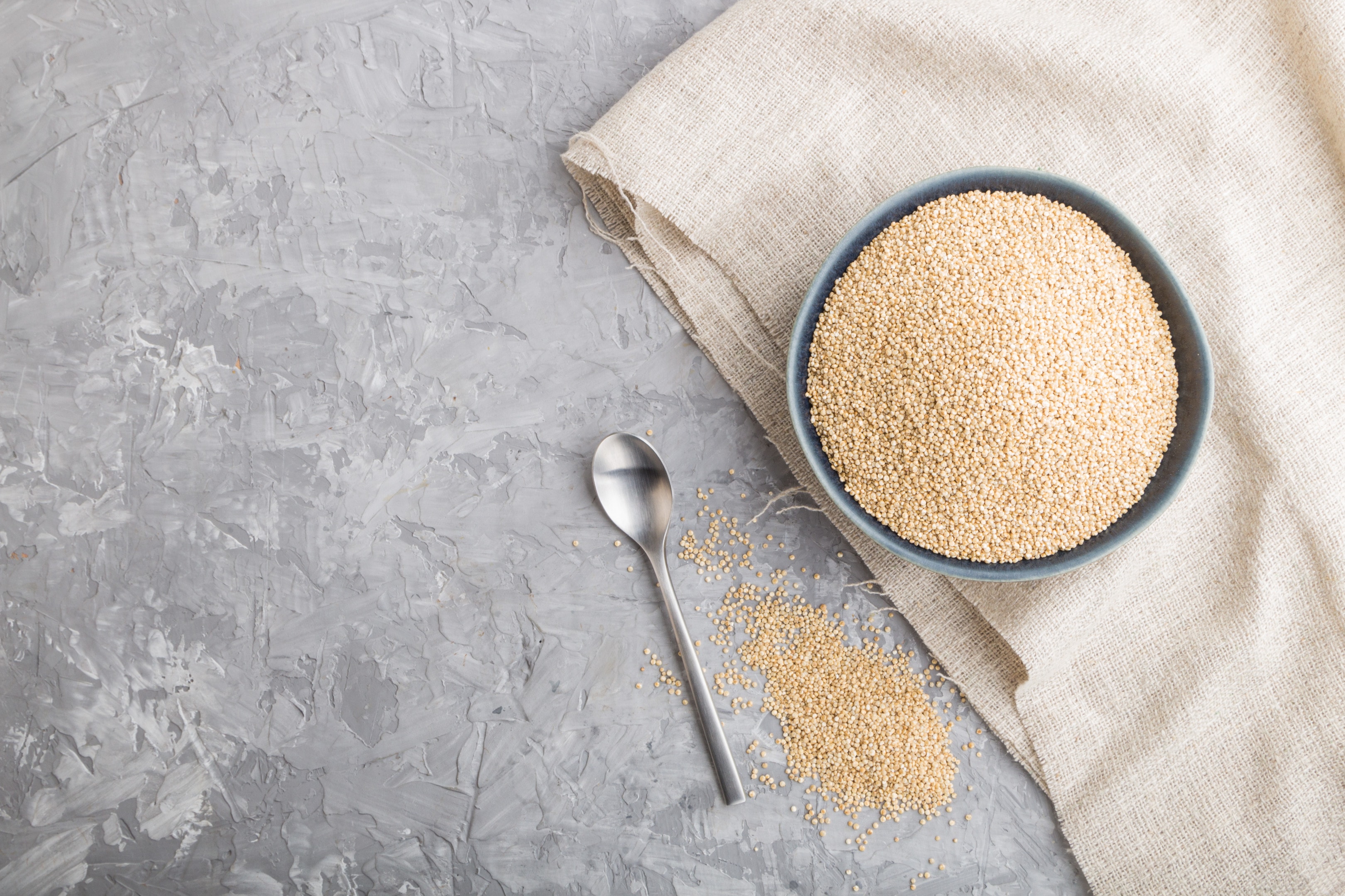 White quinoa seeds in blue ceramic bowl