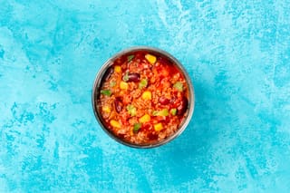 Bowl of chili con carne on a blue background