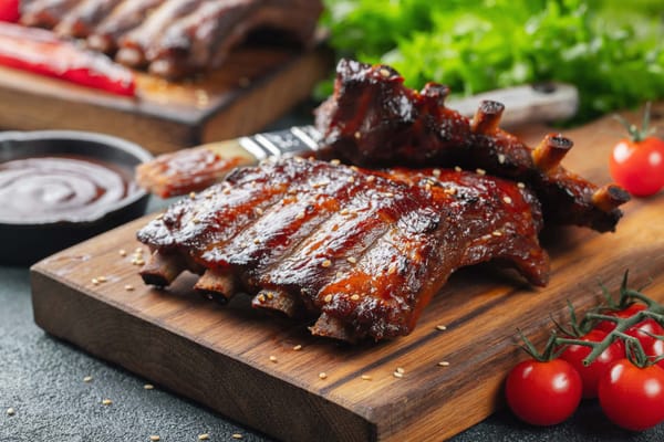 Grilled pork riblets with barbecue sauce on a cutting board