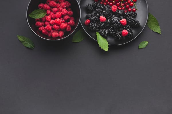 Plate and Bowl of Fresh Berries on Dark Table