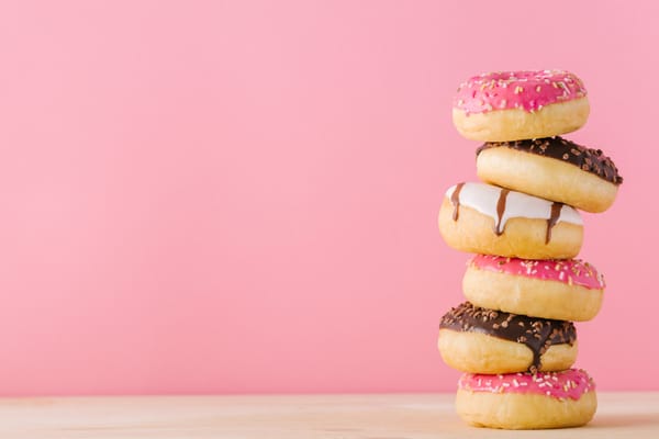 Stack of different donuts on pink background