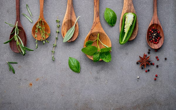 Various spices and herbs on wooden spoons