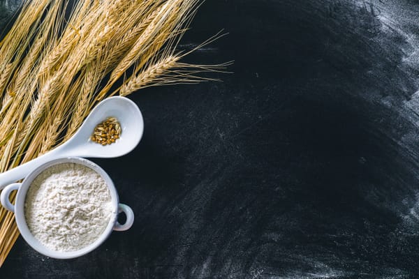 Wheat ears and wheat flour on black background