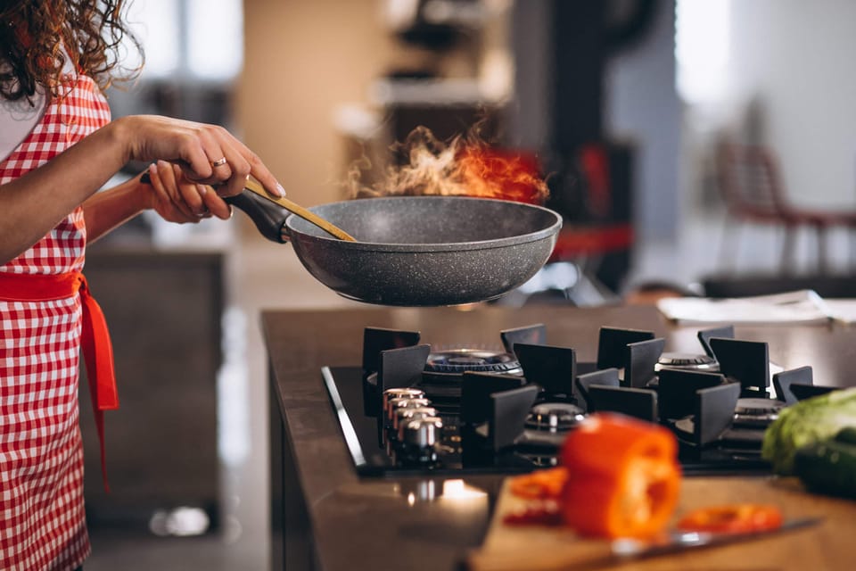 A woman cooking food with vegetables at home