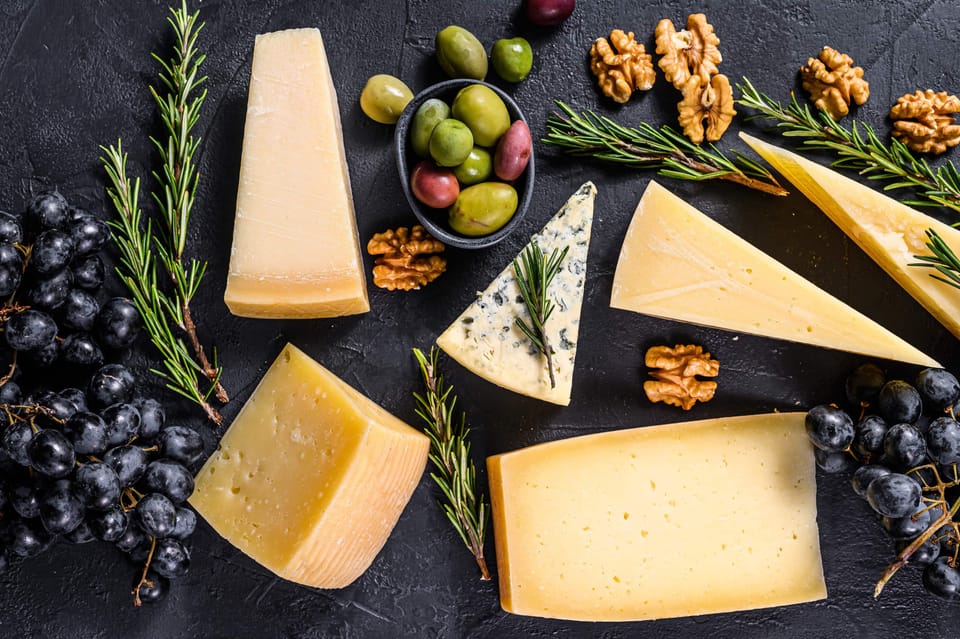 Different types delicious cheese with walnuts and grapes