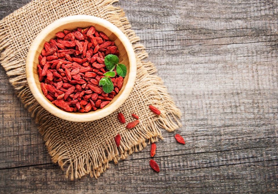 Dry red goji berries in wooden bowl