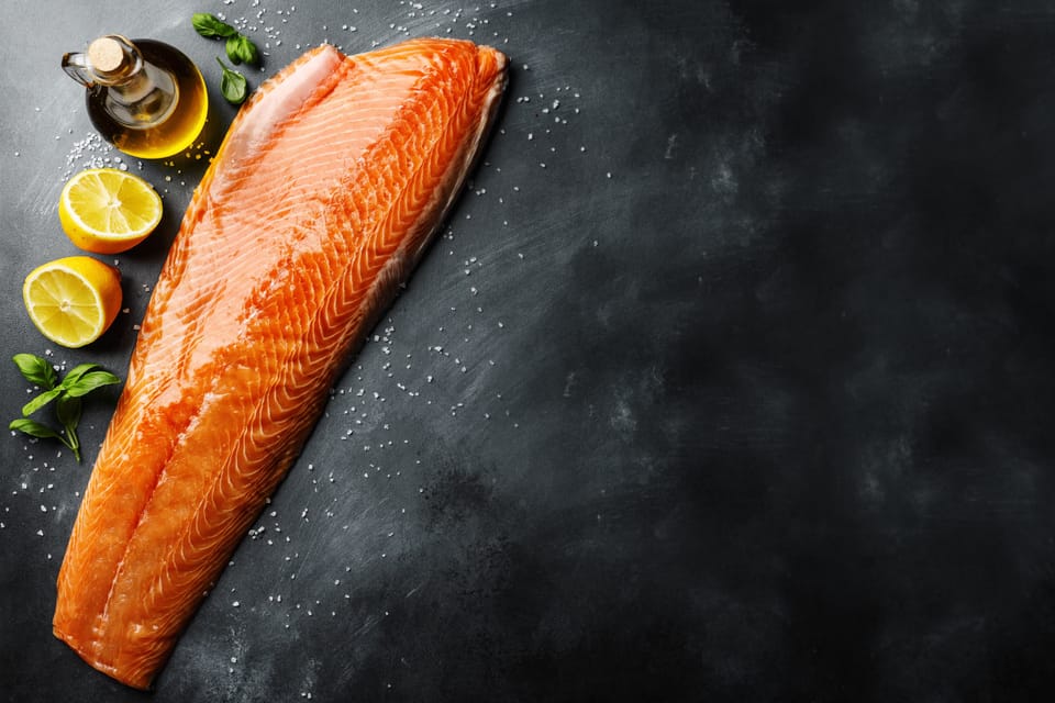 Fresh salmon with lemon on kitchen table