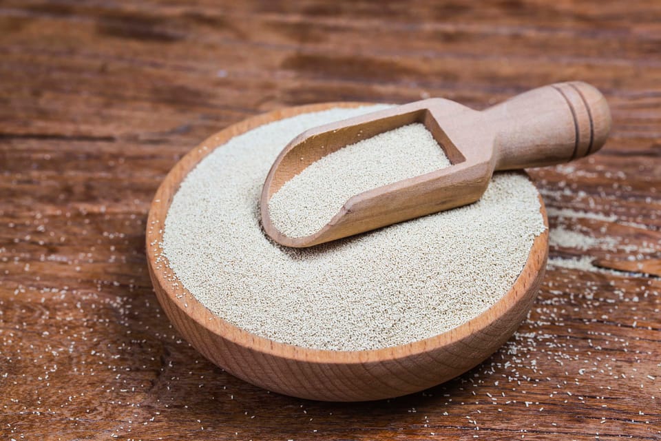 Organic raw yeast for baking bread in wooden bowl