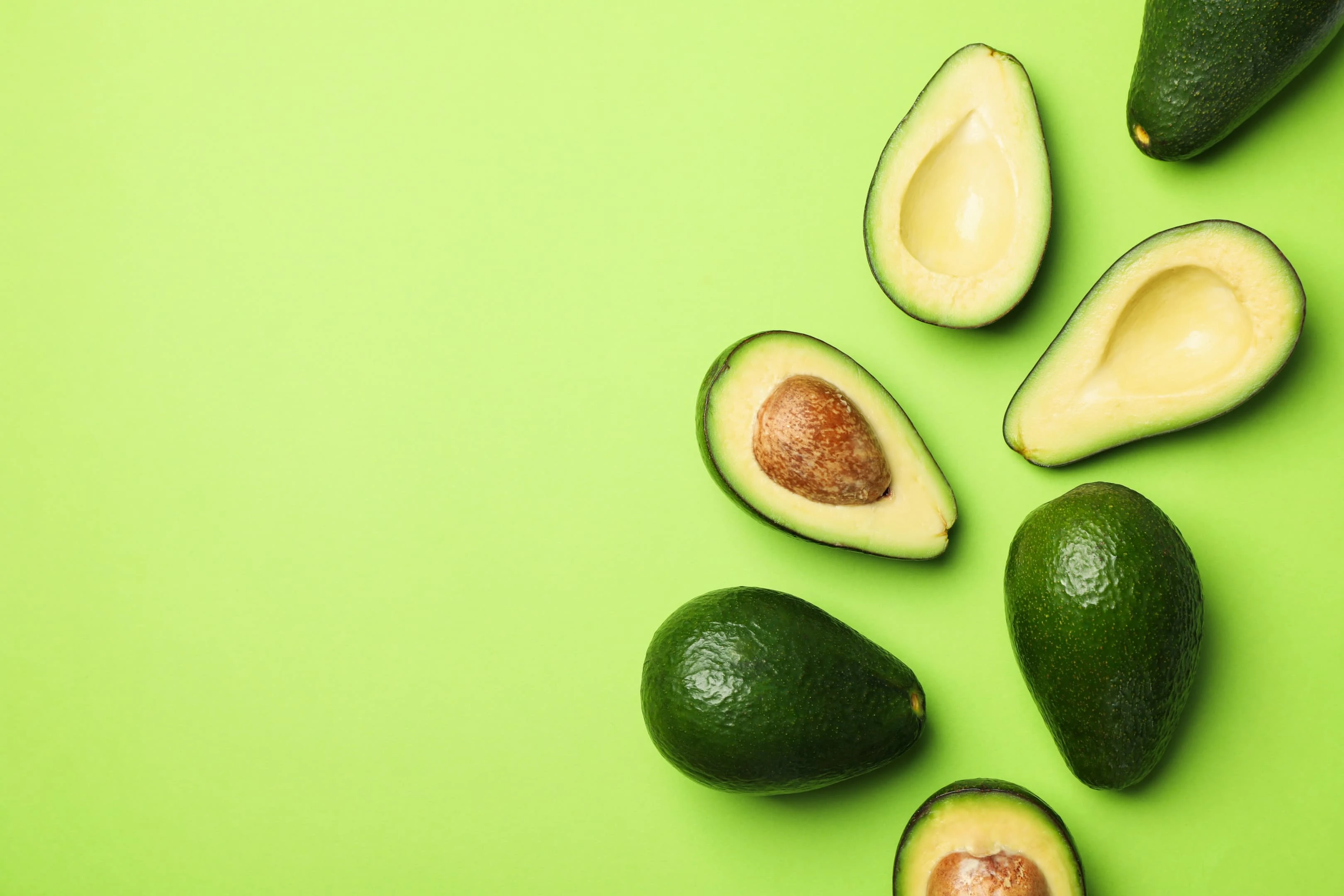 Avocados on green background