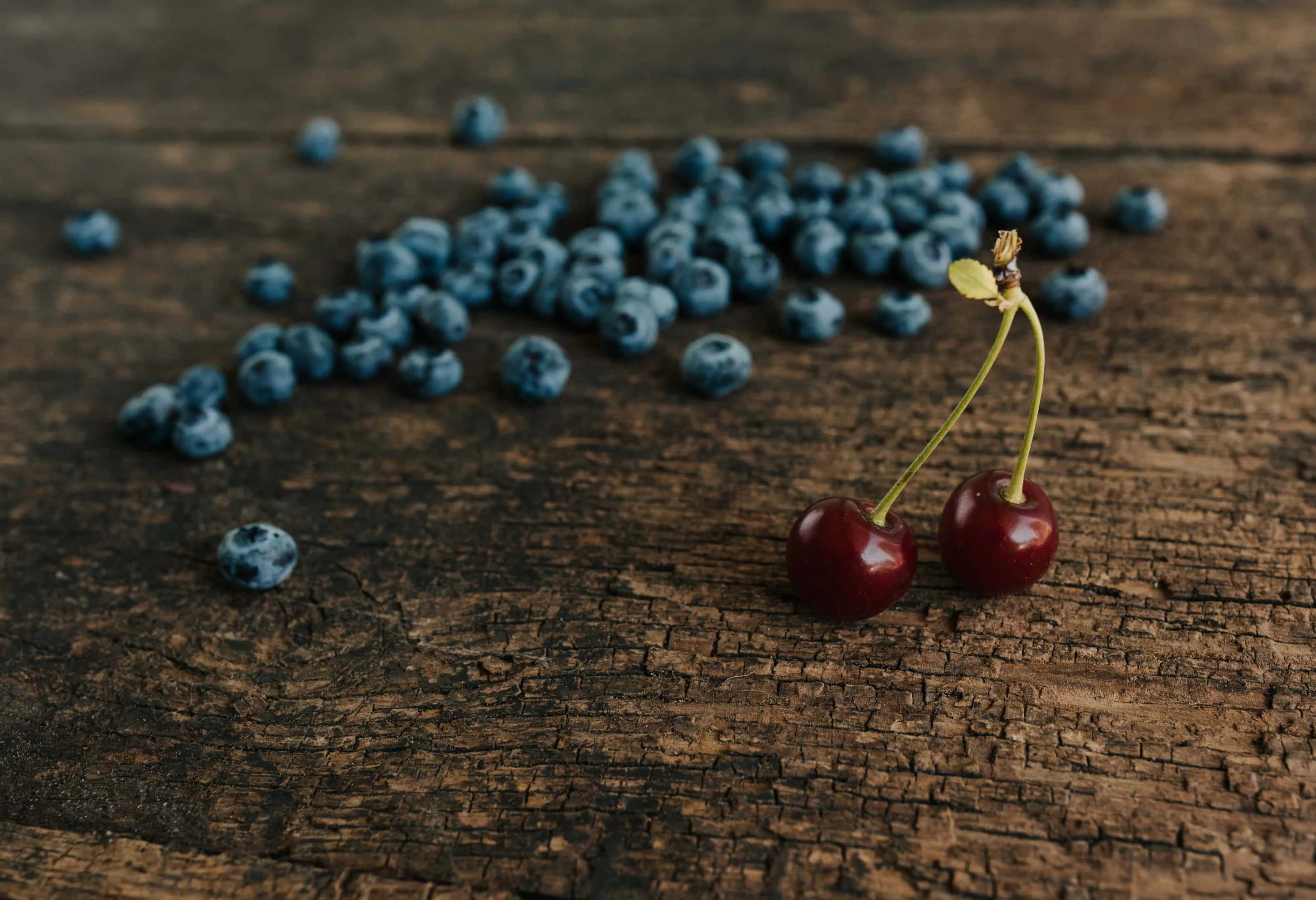 Blueberries and red cherries on wooden table
