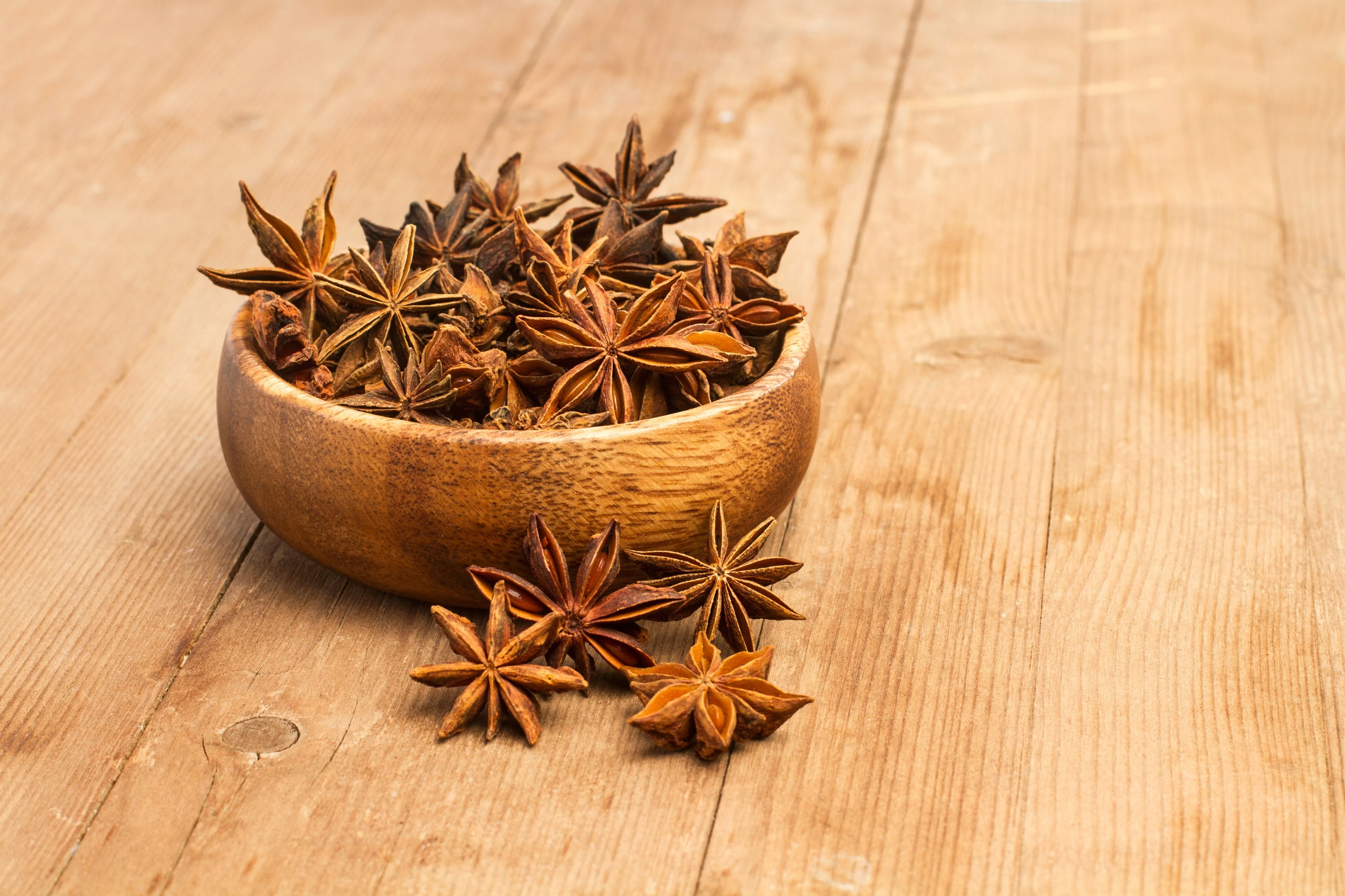 Aniseed in star anise in wooden bowl