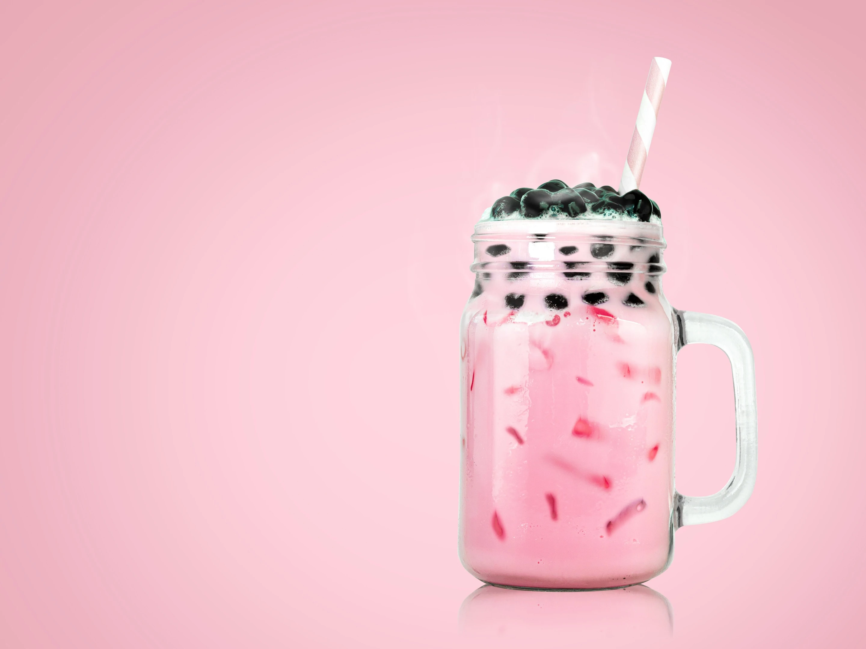 Bubble tea in clear glass on pink background