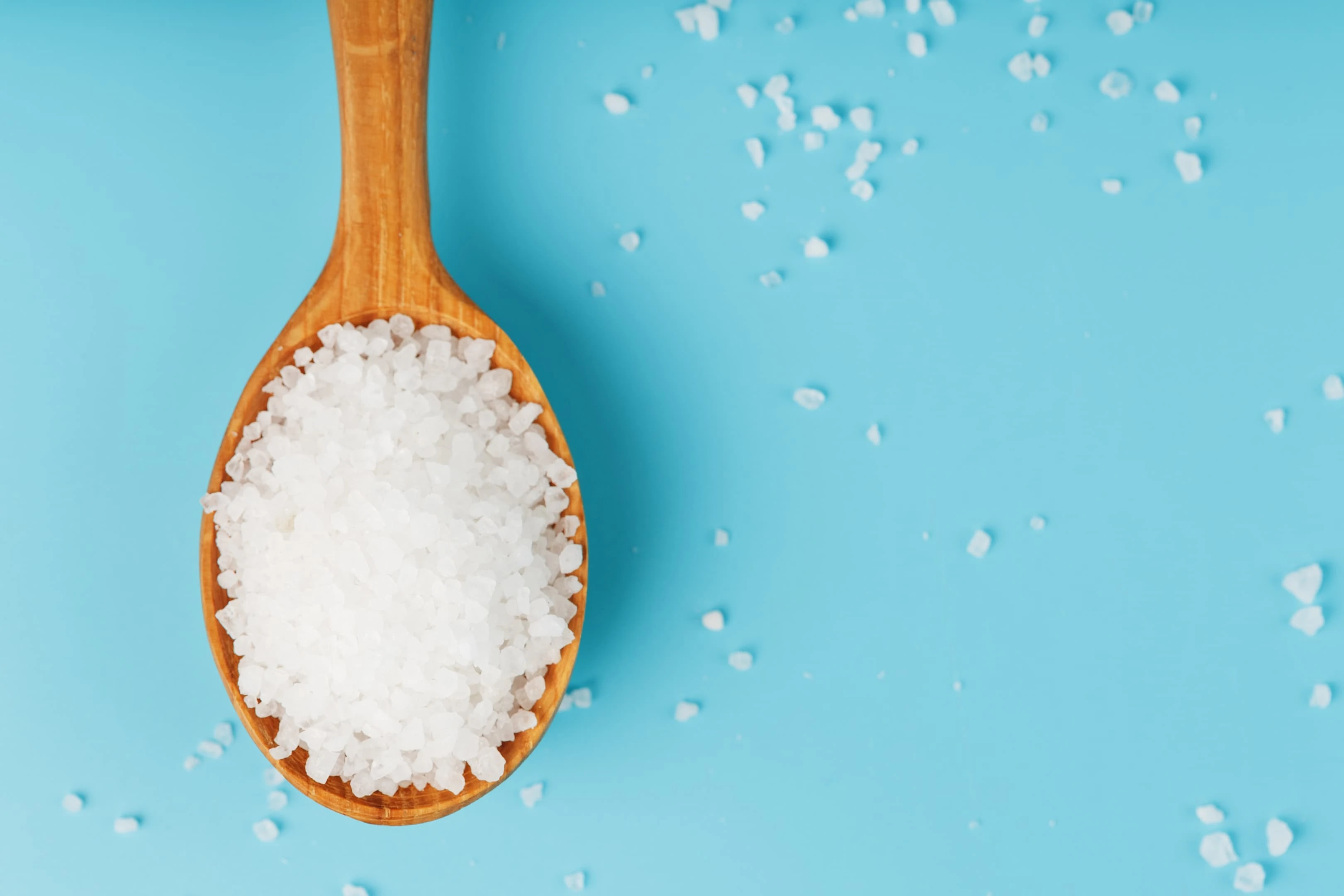 Calcium chloride large sea salt crystals on wooden spoon