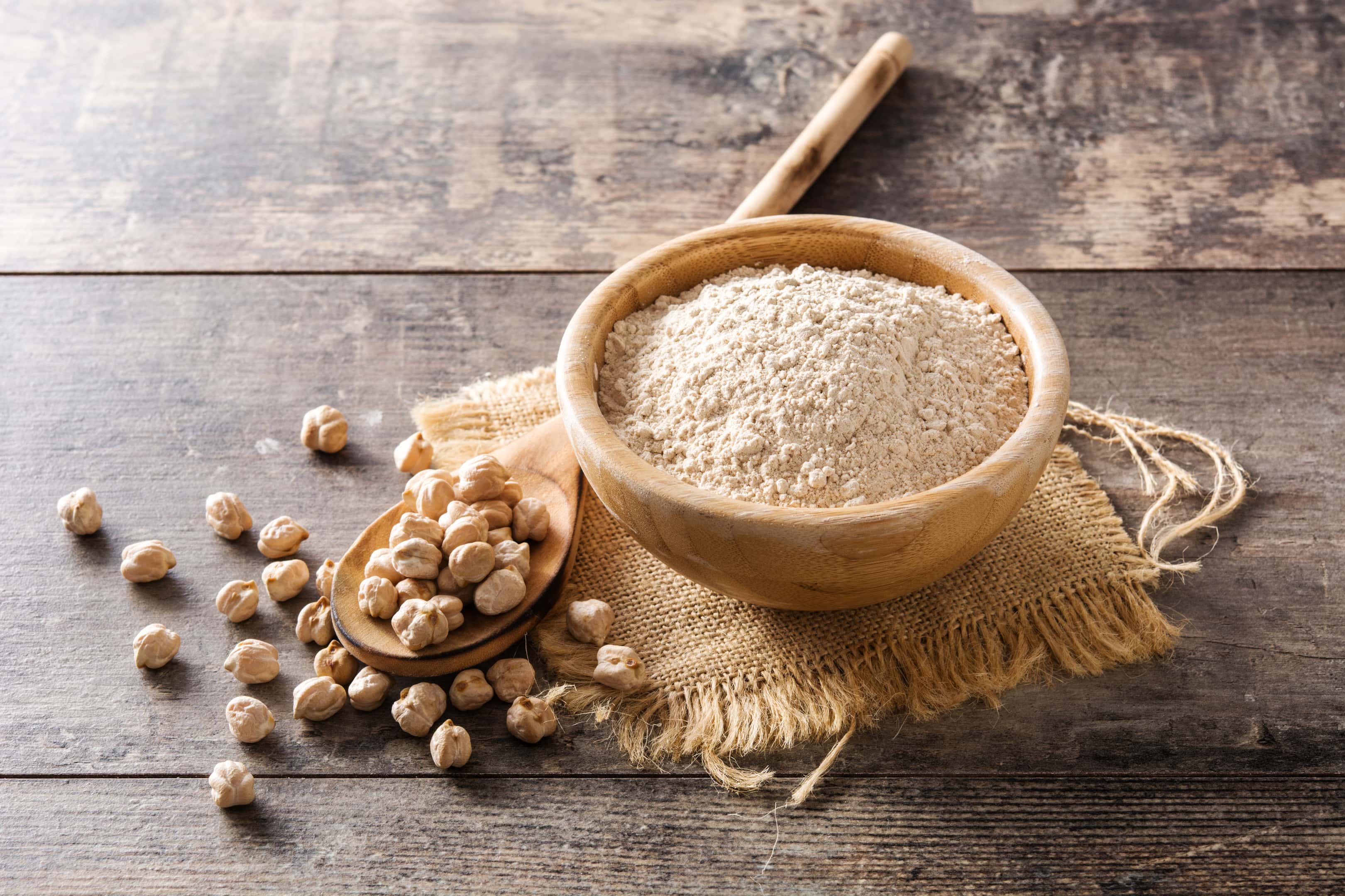 Chickpea flour in wooden bowl on wooden table