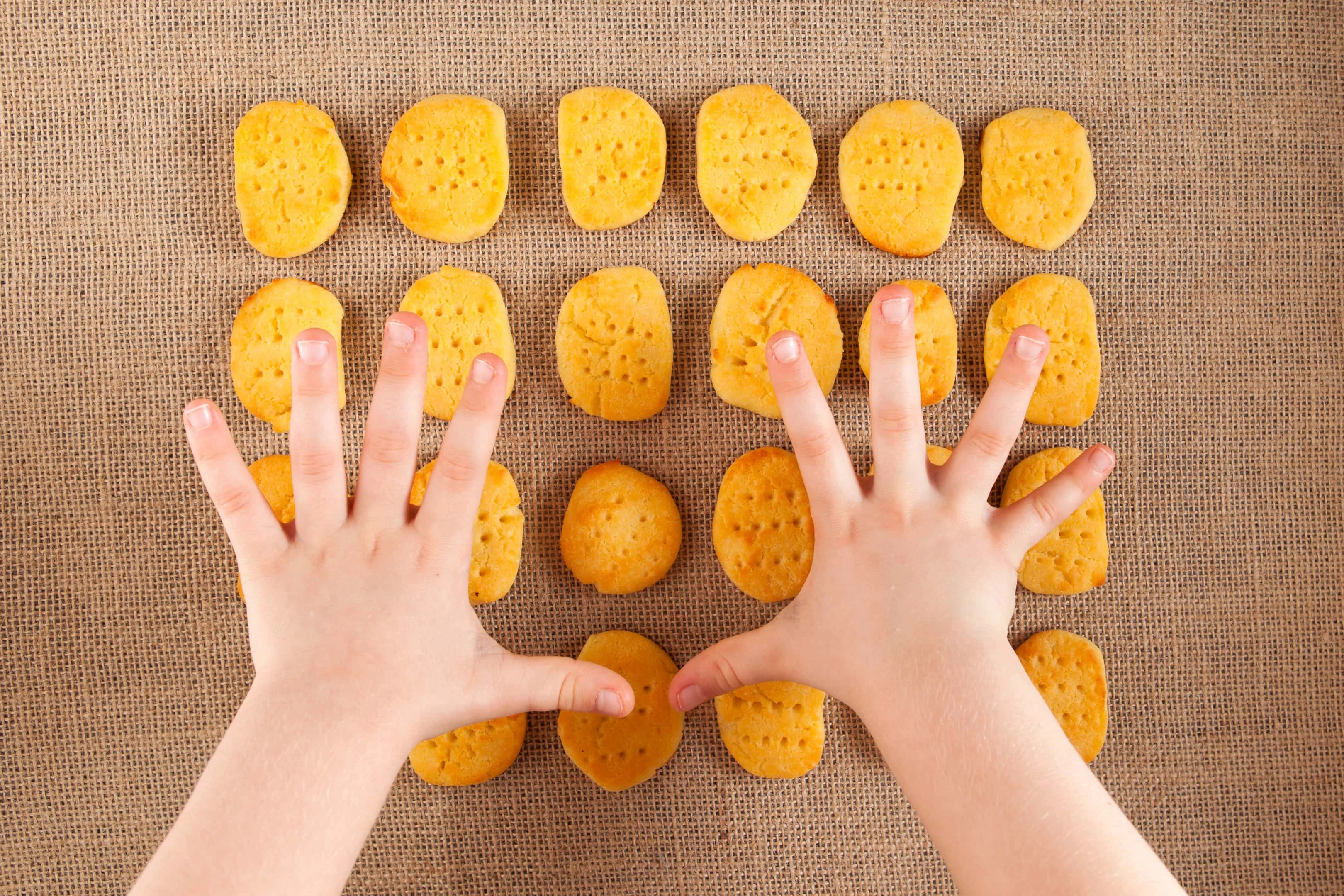Child's hands reach for Chickpea Flour Biscuits - Vegan and Gluten-Free.