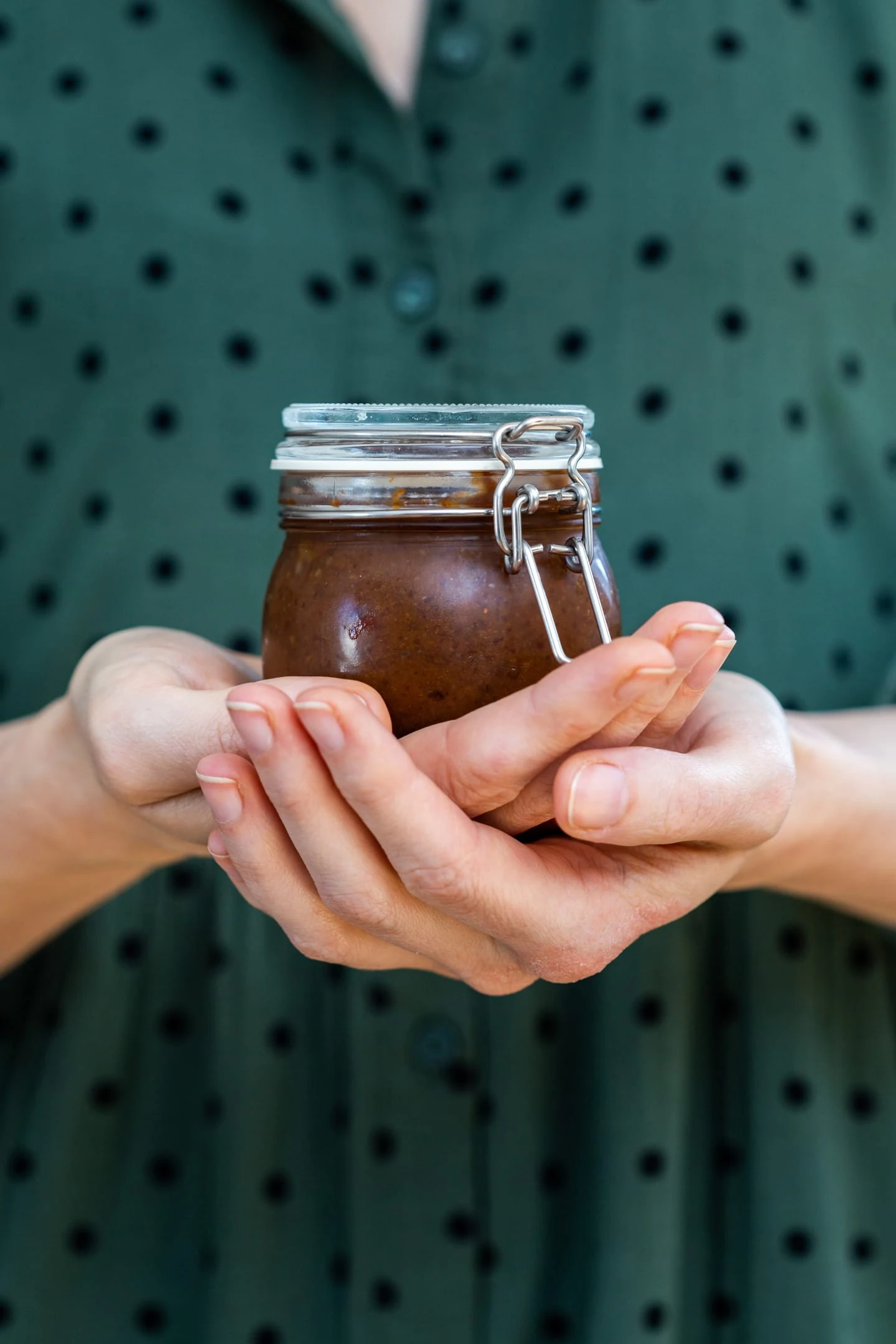 Female hands holding homemade tamarind paste jar