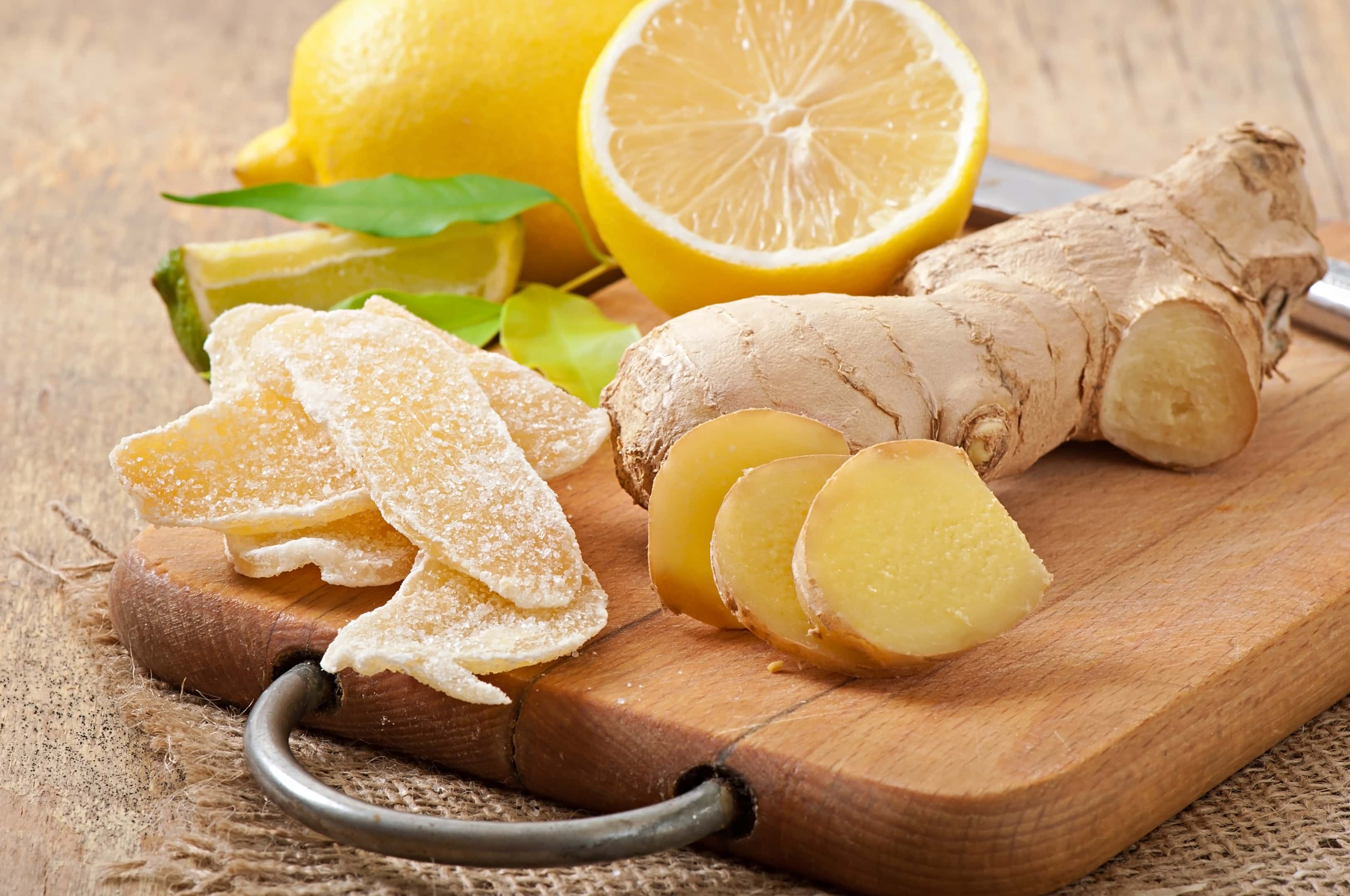Fresh ginger root and candied ginger on wooden board