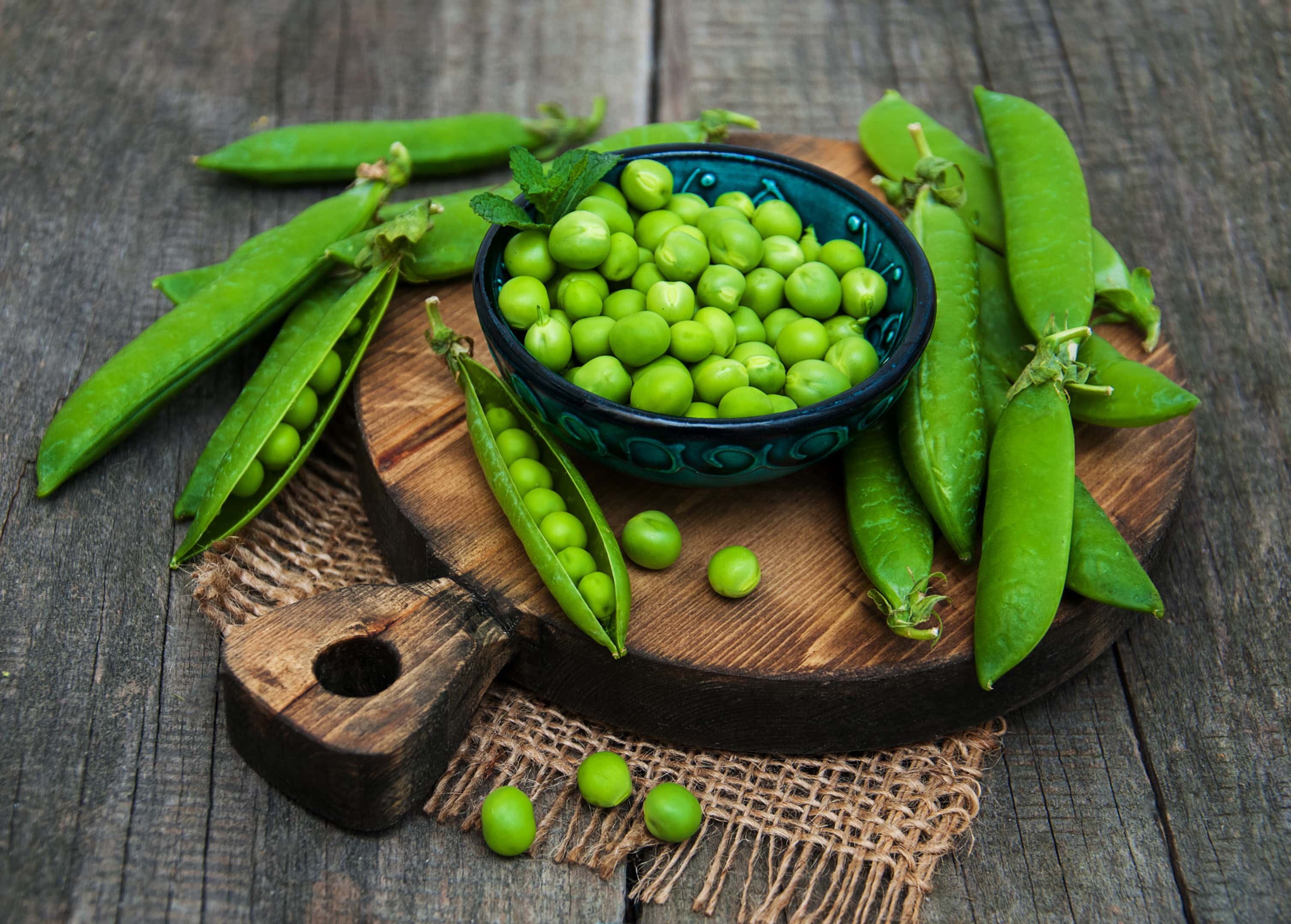 Fresh green peas on wooden board