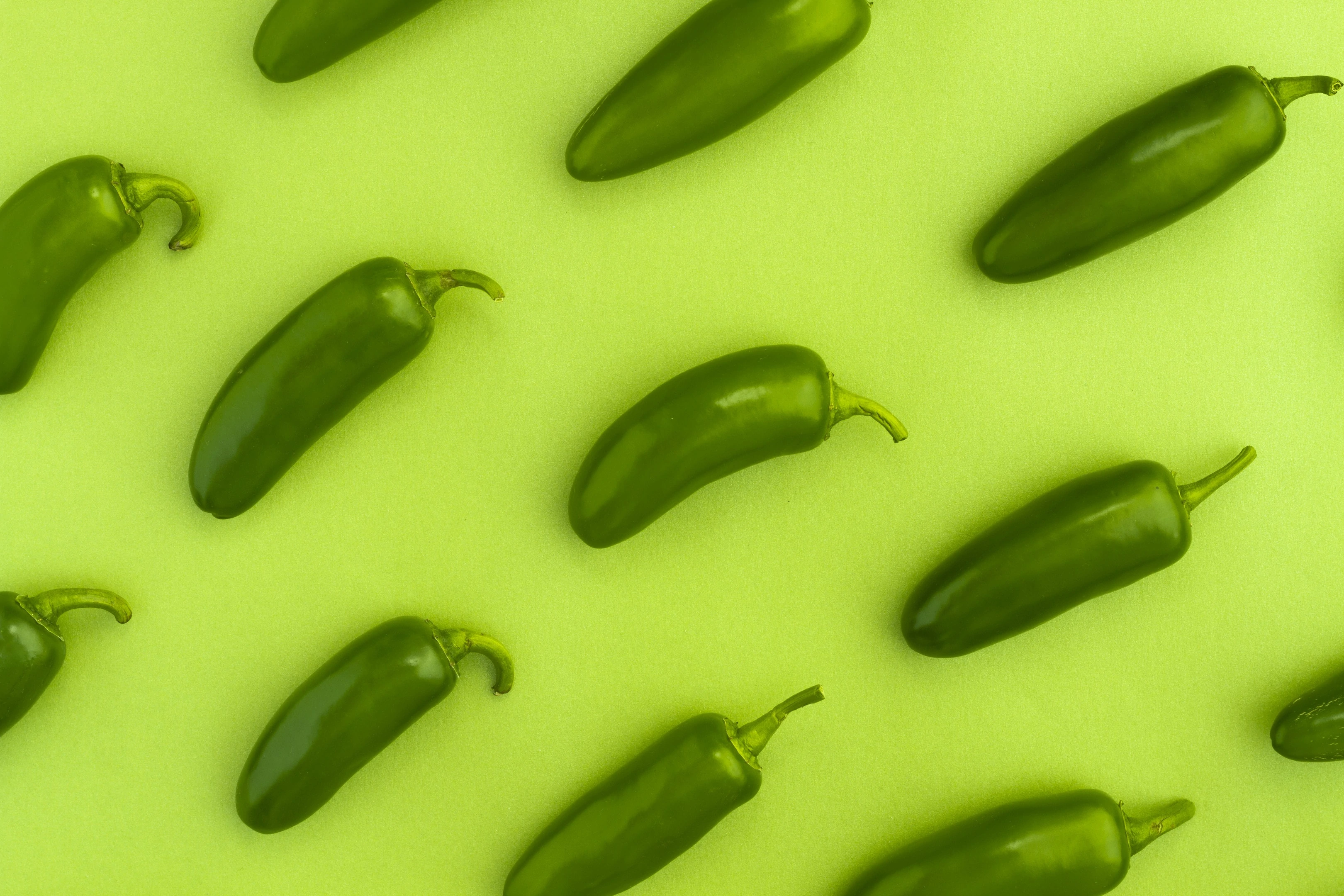 Jalapeno peppers on green background