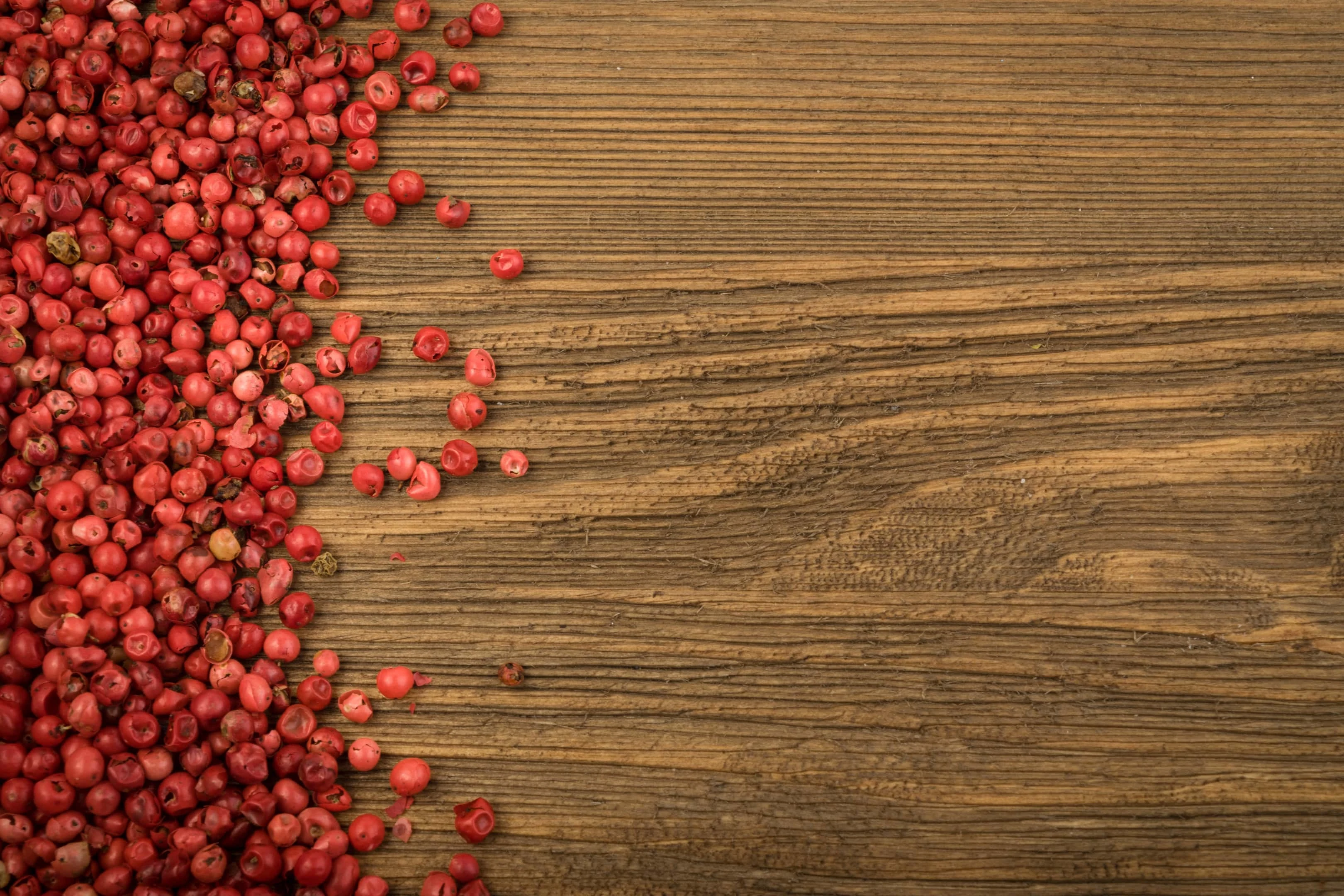 Pink peppercorn on wooden table