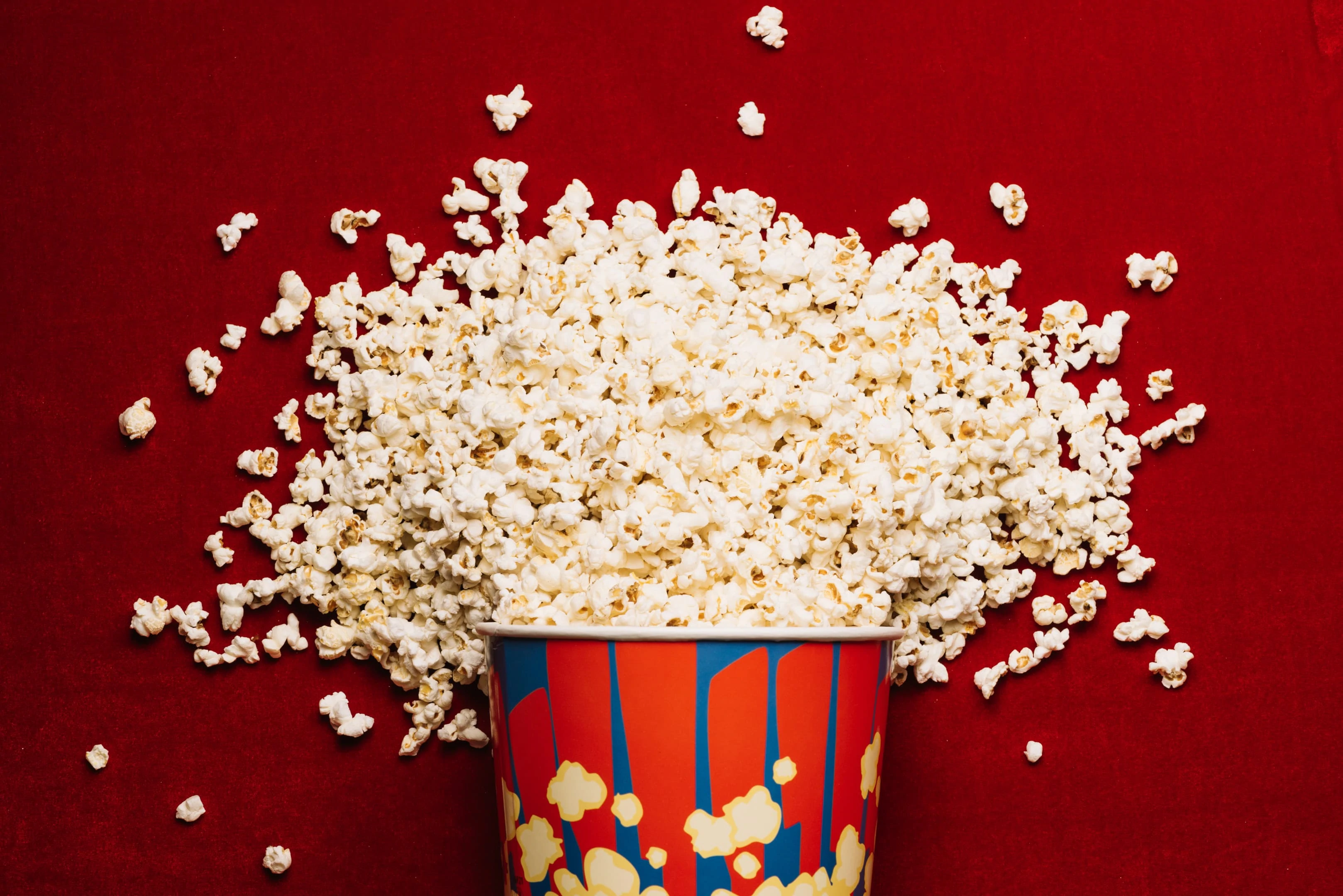 Popcorn spilled from striped bucket on cinema floor