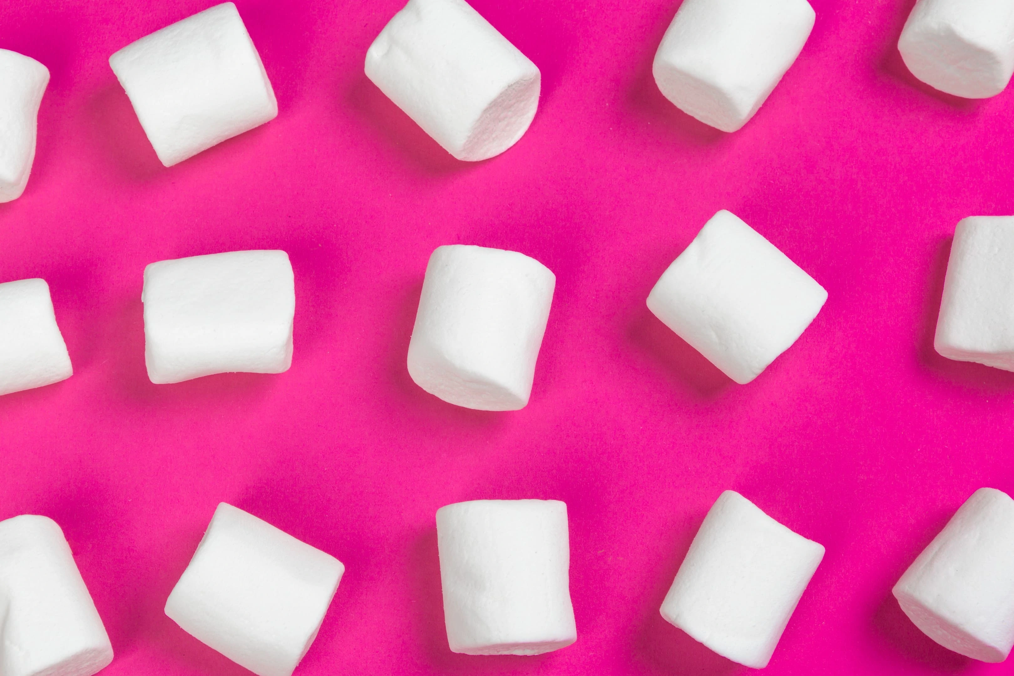 White marshmallows on a pink background