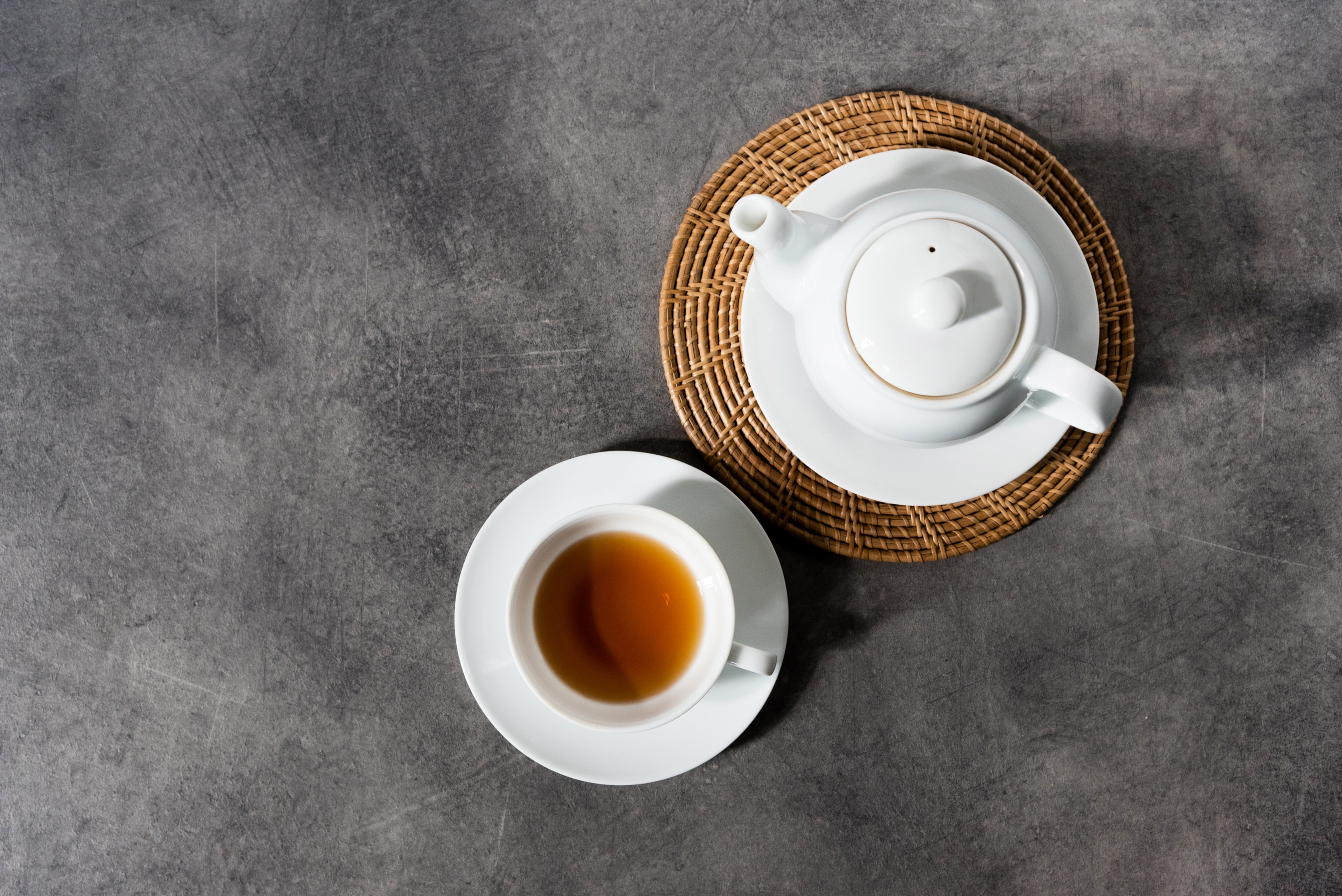 White porcelain tea cup and teapot with white tea
