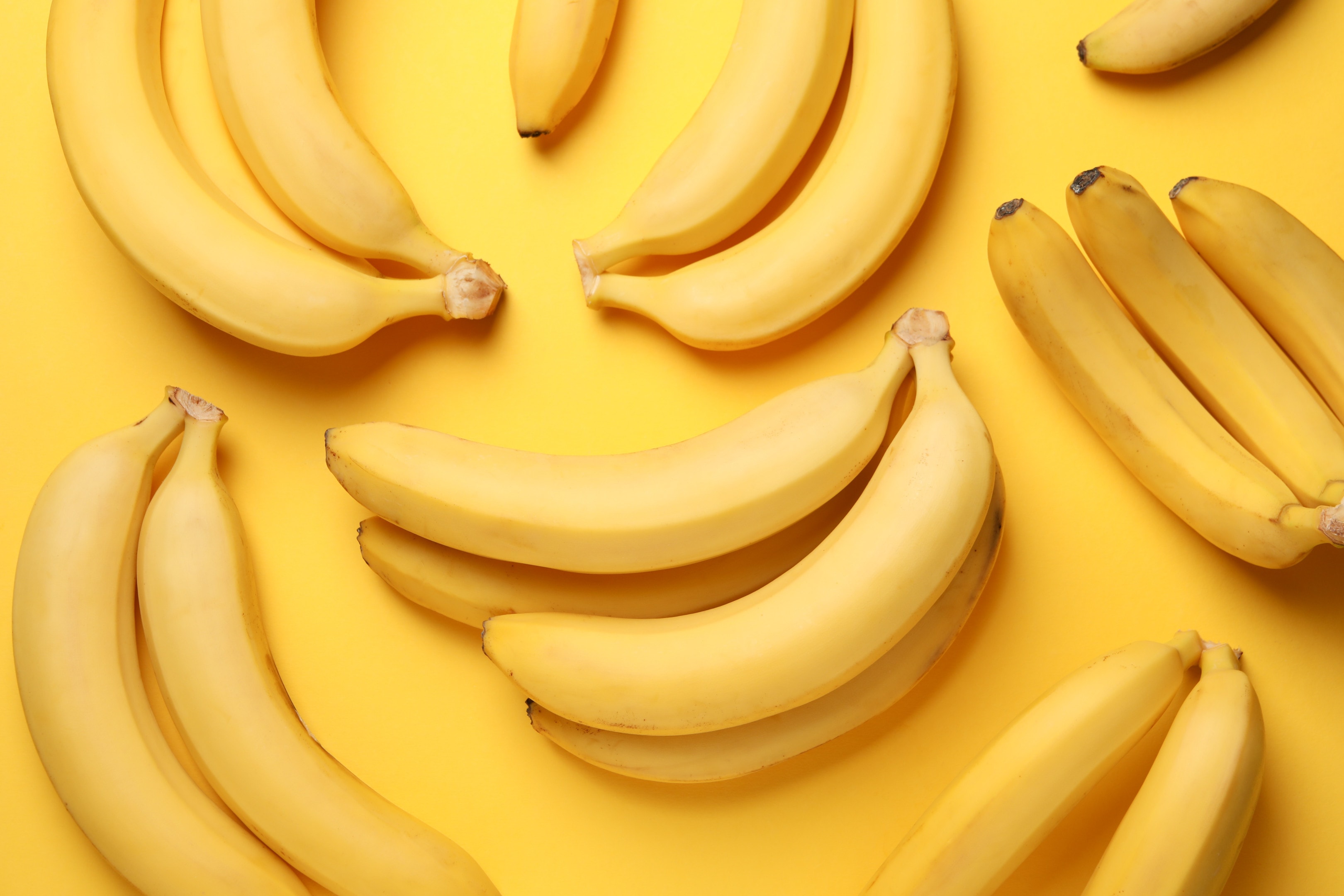 Banana clusters on yellow table