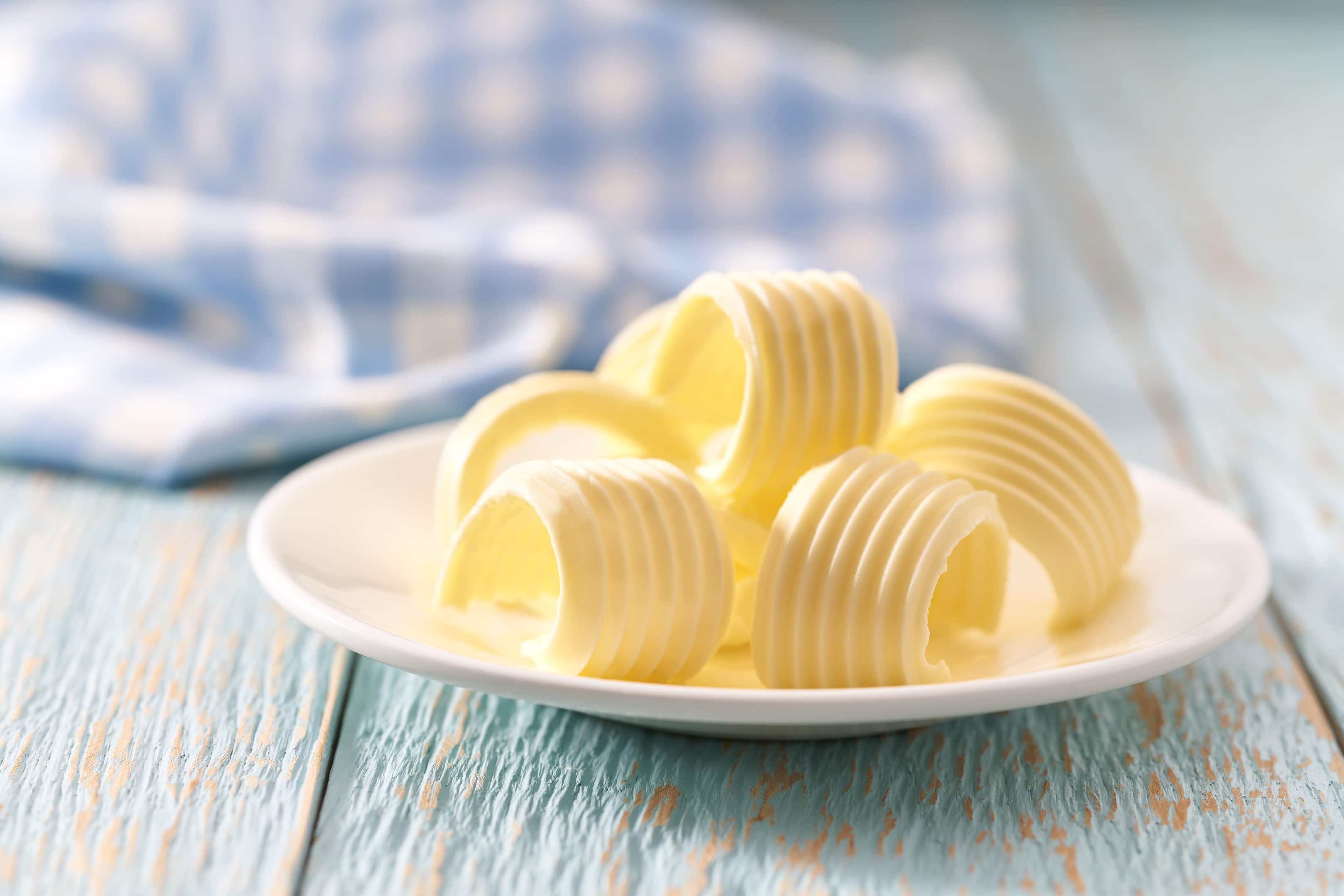 Butter curls rolls on ceramic bowl on wooden table