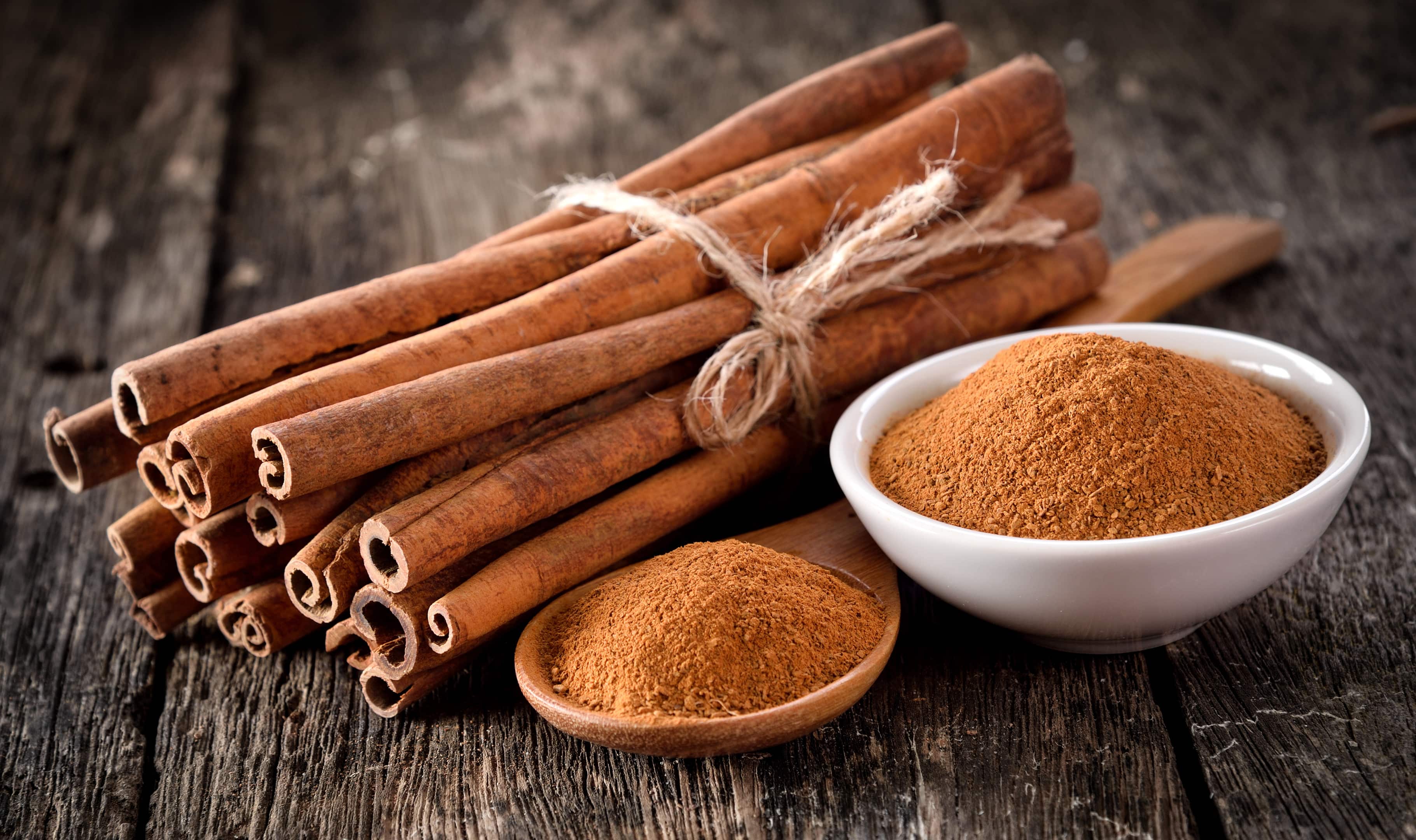 Cinnamon sticks and powder on table wooden