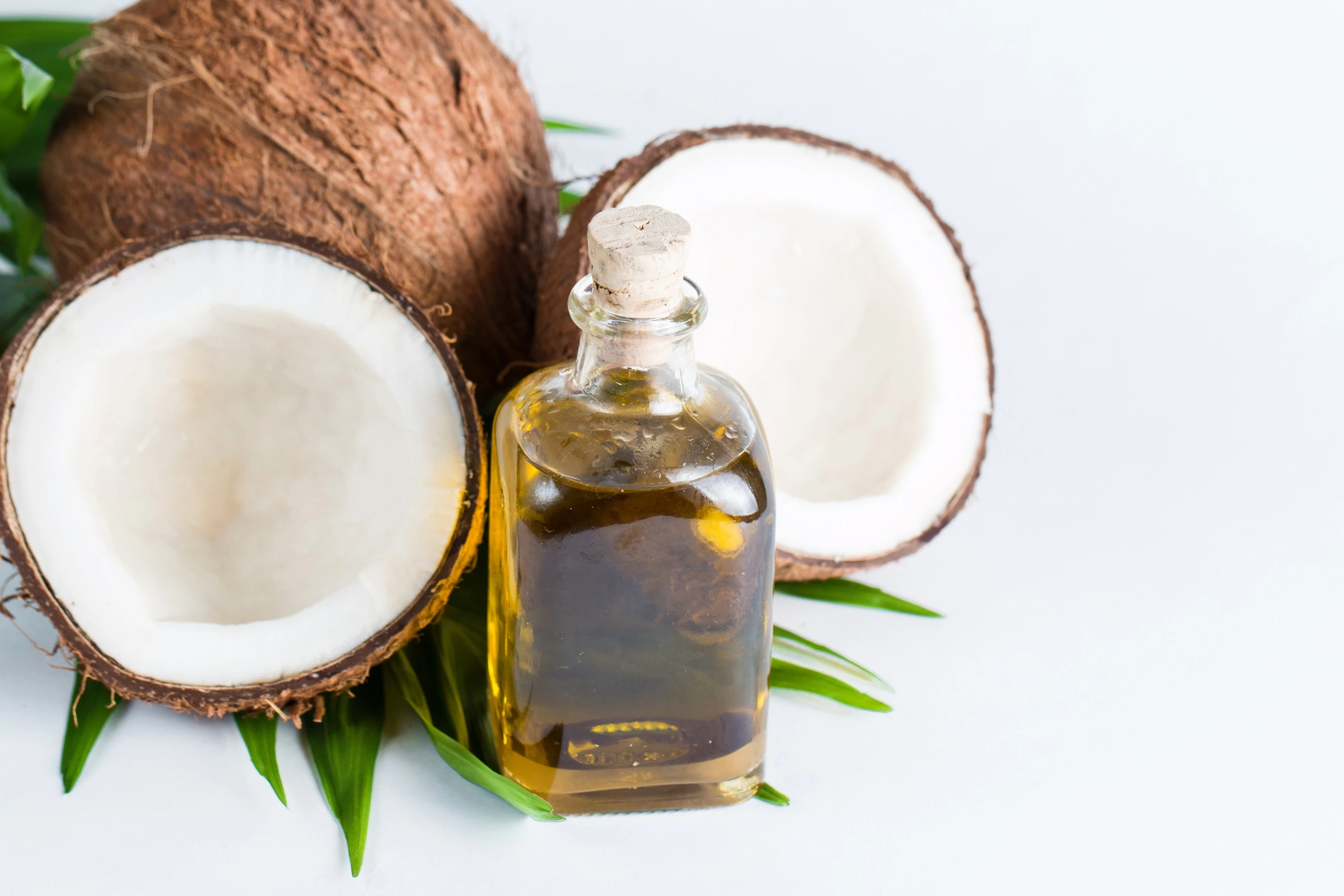 Coconut oil with fresh coconut on white background