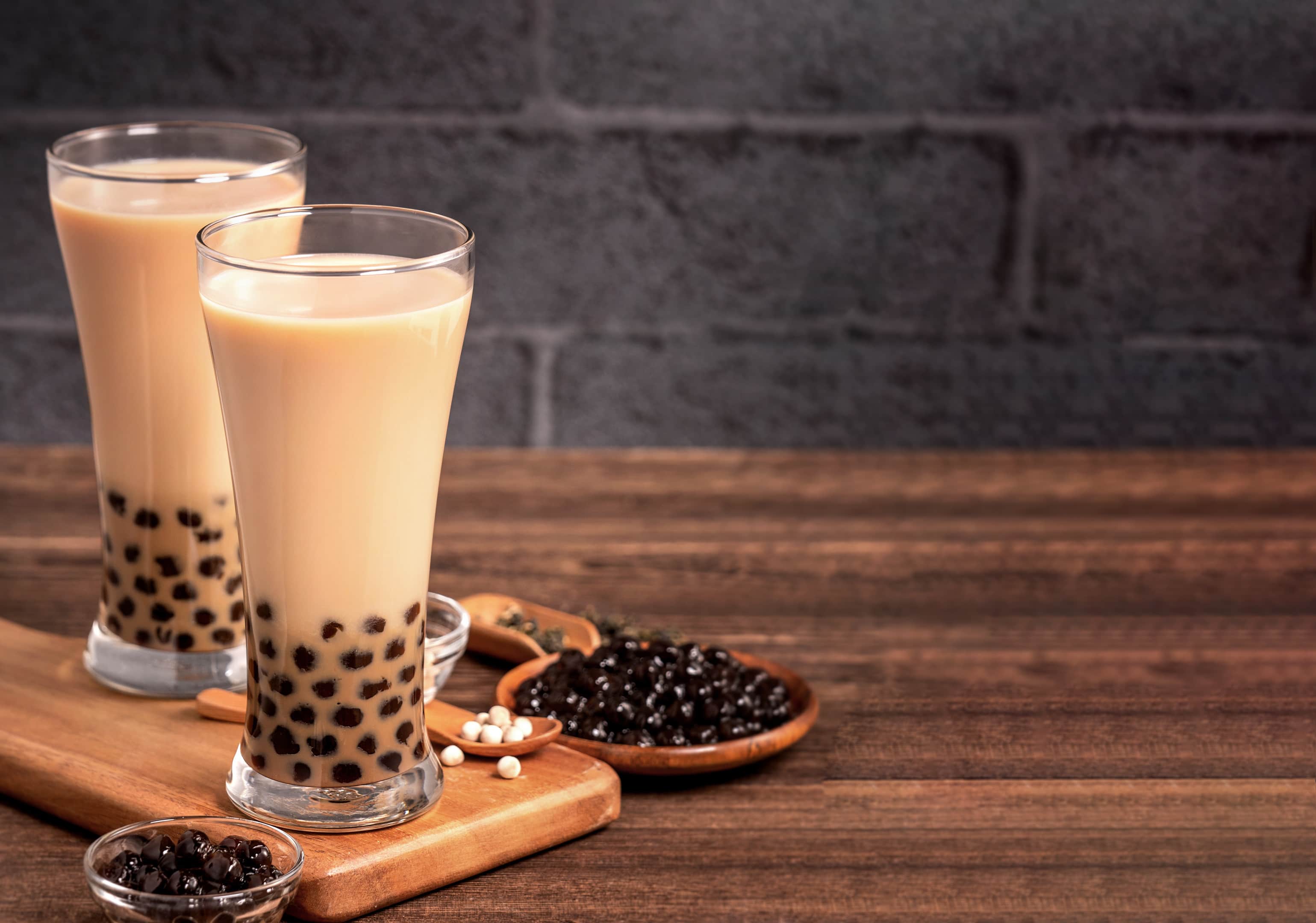 Delicious bubble milk tea with tapioca pearl ball glass on wooden table