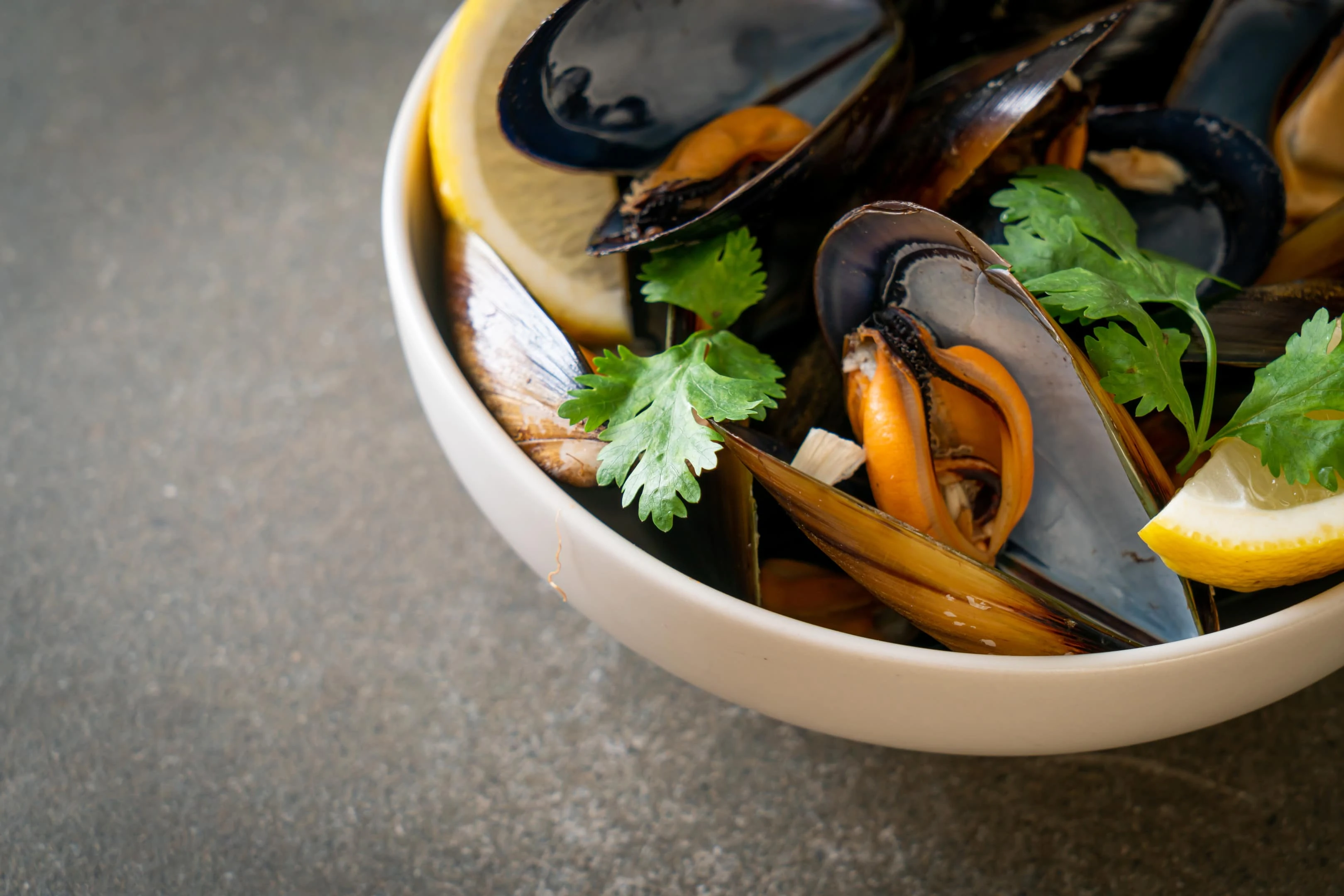 Fresh mussels with herbs in bowl
