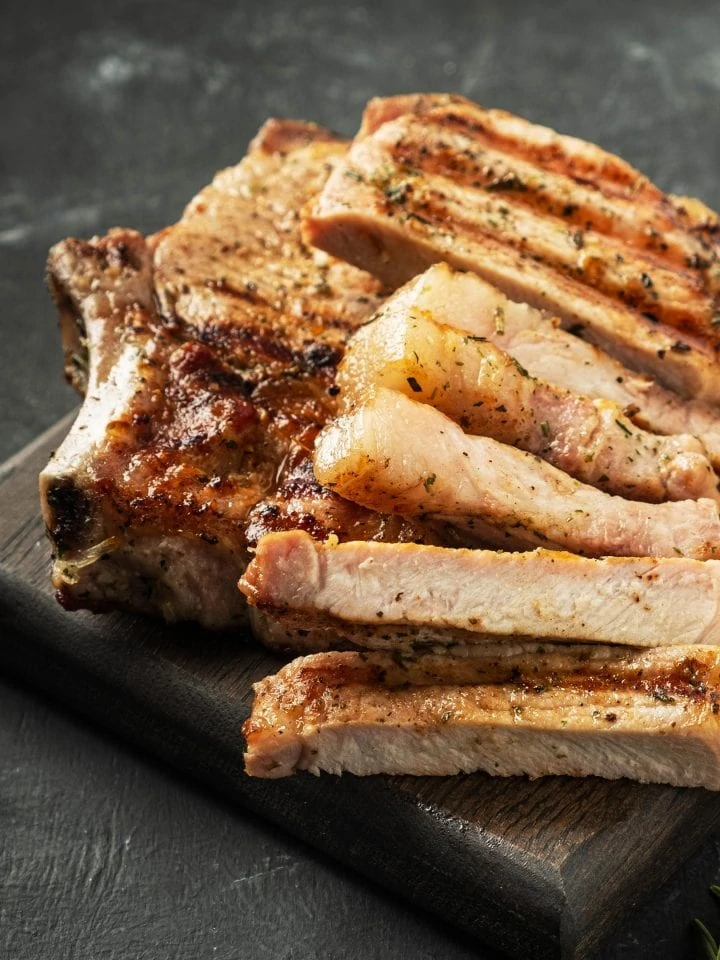 Grilled pork chops on wooden board