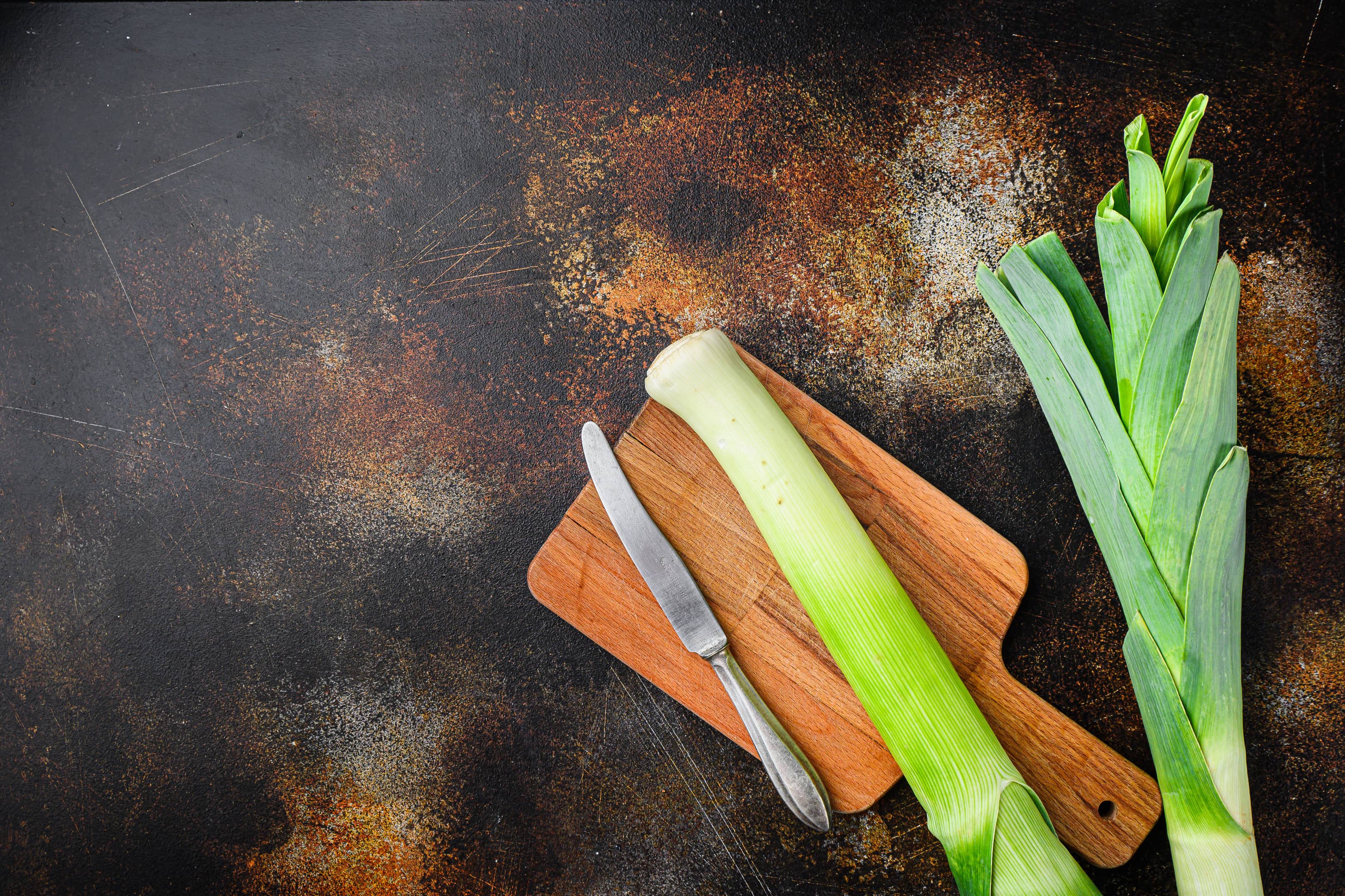 Leek stalks on wooden cutting board